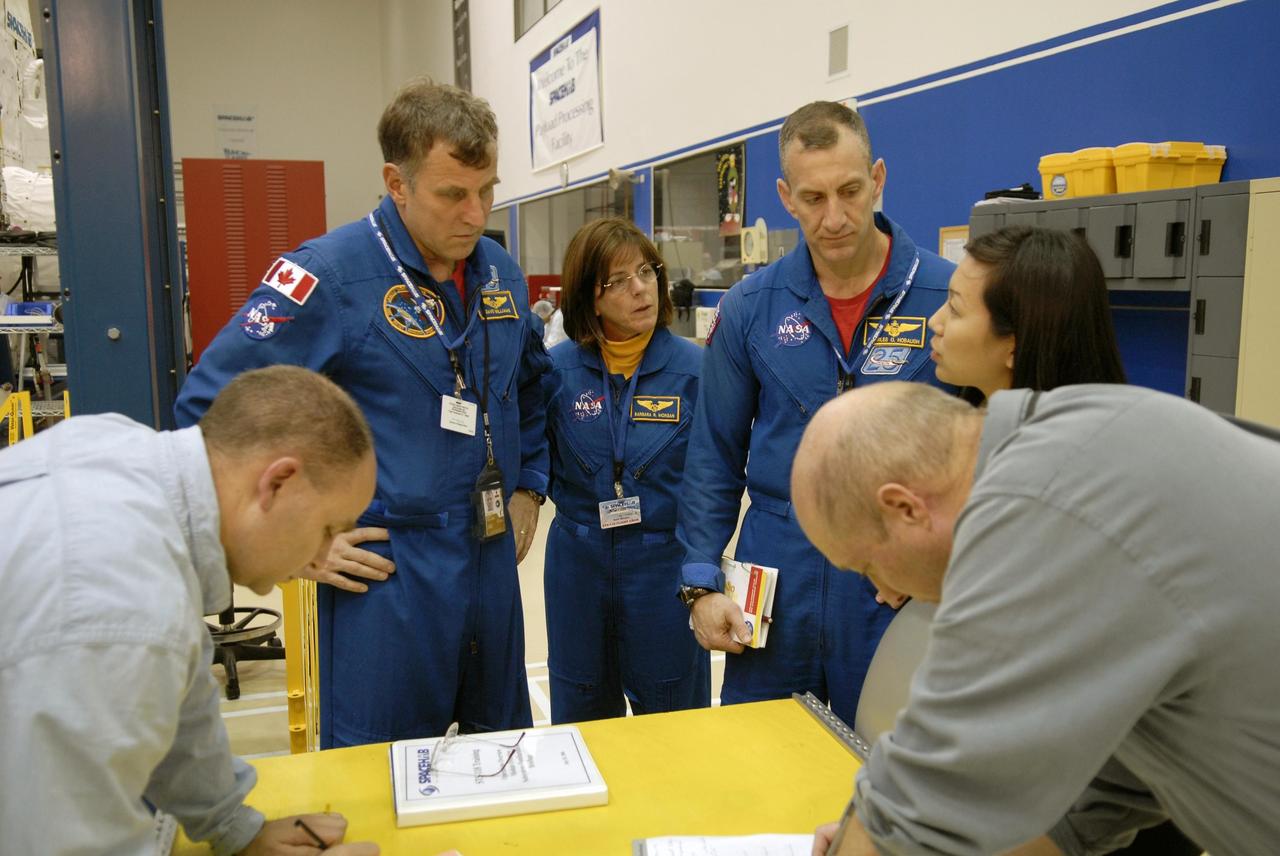 KENNEDY SPACE CENTER, FLA. -- Members of the STS-118 crew take part in a hardware review of the SPACEHAB module, part of the payload on their mission. Seen here (in uniforms) from left are Mission Specialists Dafydd Williams and Barbara Morgan and Pilot Charles Hobaugh. Williams represents the Canadian Space Agency. The mission payload also includes the third starboard truss segment (ITS S5), a control moment gyro and the external stowage platform 3 (ESP3). STS-118 is targeted to launch June 28 from Launch Pad 39A. Photo credit: NASA/Kim Shiflett