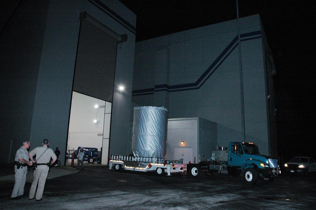 KENNEDY SPACE CENTER, FLA. --  A transport vehicle moves the covered THEMIS spacecraft away from Astrotech Space Operations in Titusville, Fla., on the start of its journey to Launch Complex 17 on Cape Canaveral Air Force Station.  On Launch Pad 17-B, the spacecraft will be mated with the third stage of the Delta II rocket.  THEMIS consists of five identical probes, the largest number of scientific satellites ever launched into orbit aboard a single rocket. The THEMIS mission is to investigate what causes auroras in the Earth's atmosphere to dramatically change from slowly shimmering waves of light to wildly shifting streaks of color. Discovering what causes auroras to change will provide scientists with important details on how the planet's magnetosphere works and the important Sun-Earth connection.  THEMIS is scheduled to launch aboard a Delta II rocket on Feb. 15 during a window extending from 6:08 to 6:27 p.m.  Photo credit: NASA/Amanda Diller