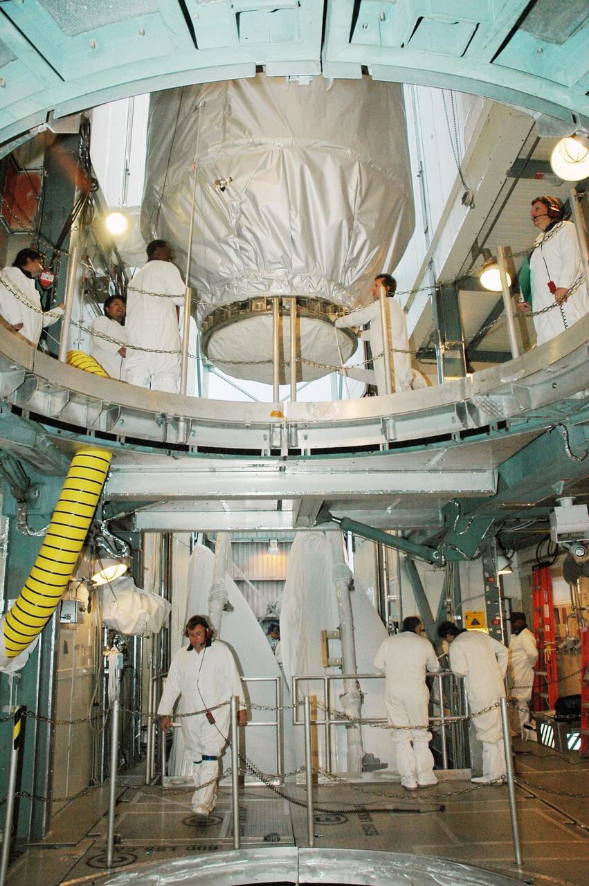 KENNEDY SPACE CENTER, FLA. --  In the upper level of the mobile service tower on Launch Pad 17-B at Cape Canaveral Air Force Station, workers help maneuver the THEMIS spacecraft into place.  They will next remove the protective cover before encapsulating and mating the spacecraft with the third stage of the Delta II rocket.  THEMIS consists of five identical probes, the largest number of scientific satellites ever launched into orbit aboard a single rocket. The THEMIS mission is to investigate what causes auroras in the Earth's atmosphere to dramatically change from slowly shimmering waves of light to wildly shifting streaks of color. Discovering what causes auroras to change will provide scientists with important details on how the planet's magnetosphere works and the important Sun-Earth connection.  THEMIS is scheduled to launch aboard a Delta II rocket on Feb. 15 during a window extending from 6:08 to 6:27 p.m.  Photo credit: NASA/Amanda Diller
