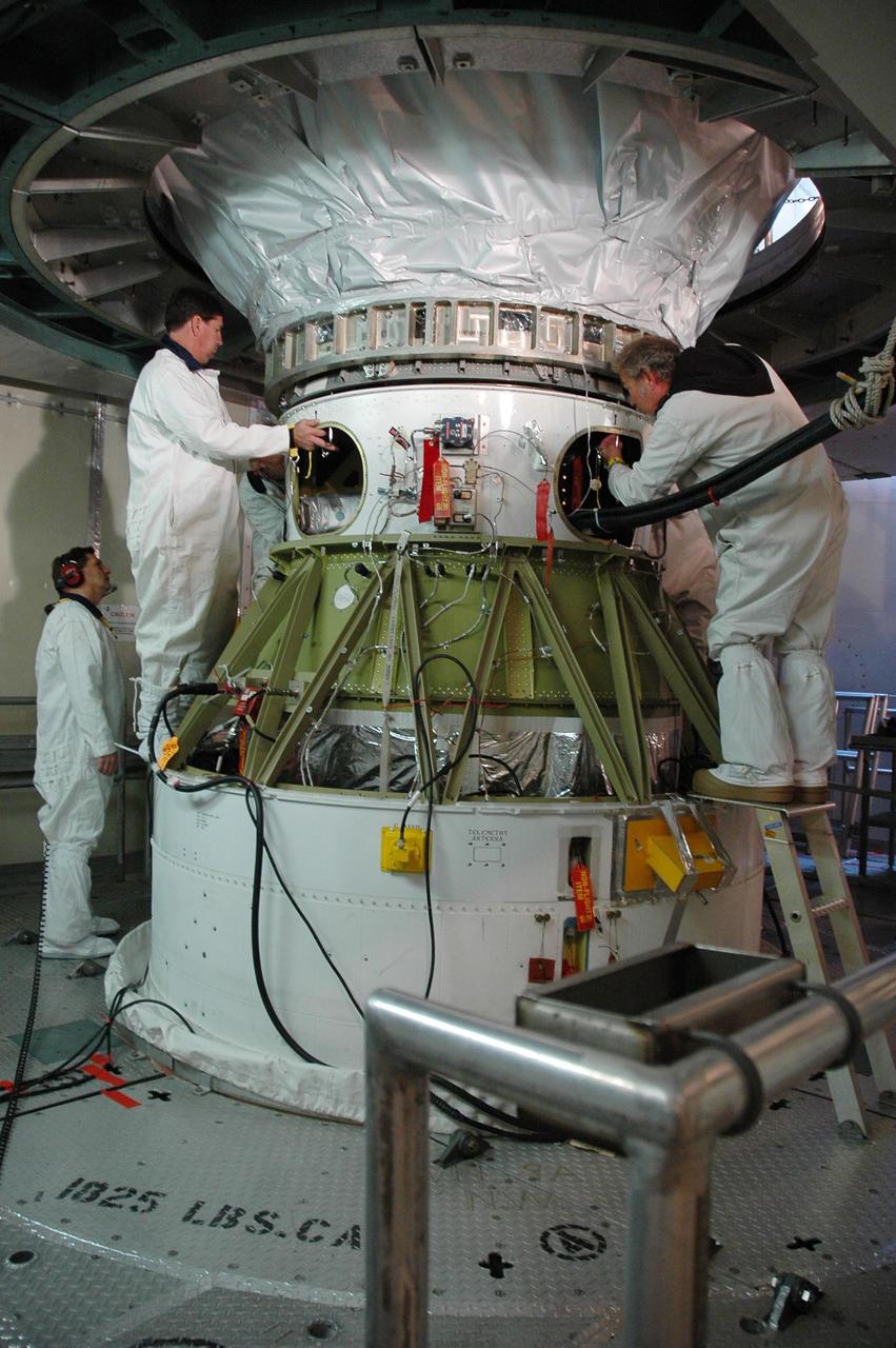 KENNEDY SPACE CENTER, FLA. --  Inside the mobile service tower on Launch Pad 17-B at Cape Canaveral Air Force Station, workers remove the protective cover surrounding the THEMIS spacecraft.  THEMIS consists of five identical probes, the largest number of scientific satellites ever launched into orbit aboard a single rocket. The THEMIS mission is to investigate what causes auroras in the Earth's atmosphere to dramatically change from slowly shimmering waves of light to wildly shifting streaks of color. Discovering what causes auroras to change will provide scientists with important details on how the planet's magnetosphere works and the important Sun-Earth connection.  THEMIS is scheduled to launch aboard a Delta II rocket on Feb. 15 during a window extending from 6:08 to 6:27 p.m.  Photo credit: NASA/Amanda Diller