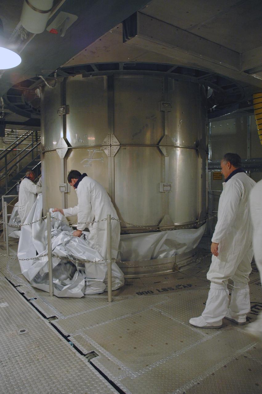KENNEDY SPACE CENTER, FLA. --  Inside the mobile service tower on Launch Pad 17-B at Cape Canaveral Air Force Station, workers remove the protective cover surrounding the THEMIS spacecraft.  THEMIS consists of five identical probes, the largest number of scientific satellites ever launched into orbit aboard a single rocket. The THEMIS mission is to investigate what causes auroras in the Earth's atmosphere to dramatically change from slowly shimmering waves of light to wildly shifting streaks of color. Discovering what causes auroras to change will provide scientists with important details on how the planet's magnetosphere works and the important Sun-Earth connection.  THEMIS is scheduled to launch aboard a Delta II rocket on Feb. 15 during a window extending from 6:08 to 6:27 p.m.  Photo credit: NASA/Amanda Diller