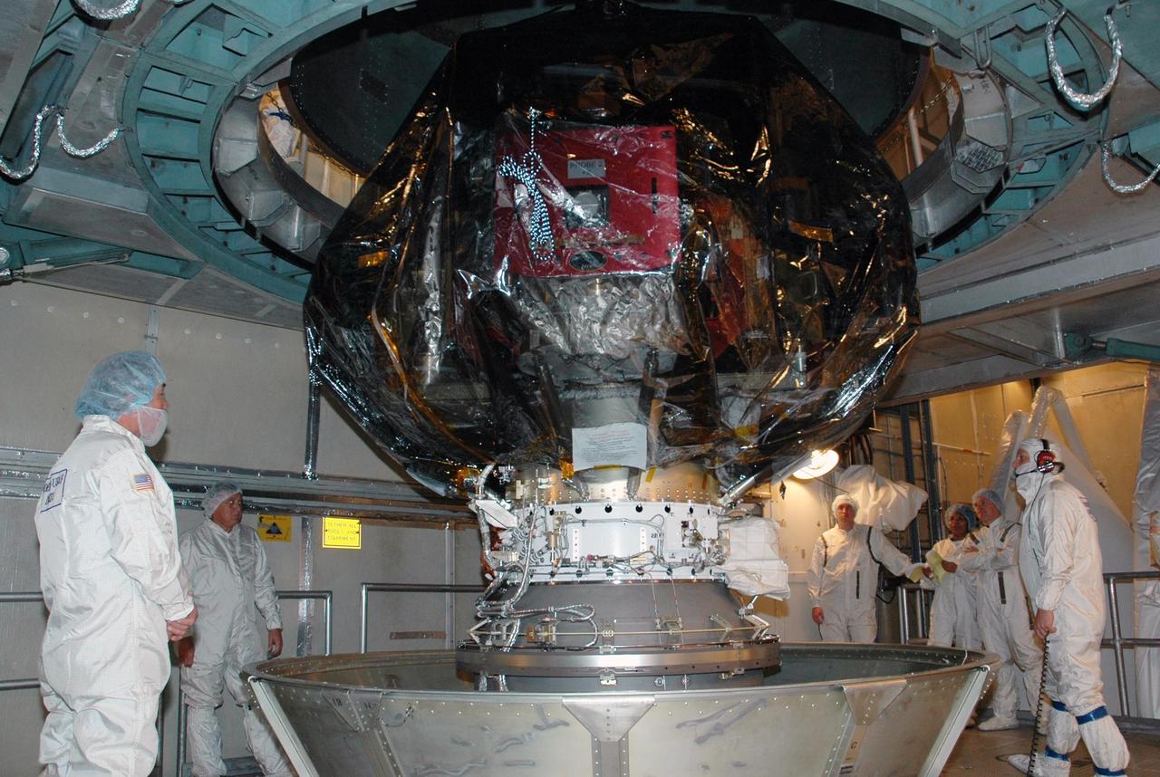 KENNEDY SPACE CENTER, FLA. -- Workers inside the mobile service tower on Launch Pad 17-B at Cape Canaveral Air Force Station watch as the upper canister is lifted away from the THEMIS spacecraft. THEMIS consists of five identical probes, the largest number of scientific satellites ever launched into orbit aboard a single rocket. The THEMIS mission is to investigate what causes auroras in the Earth's atmosphere to dramatically change from slowly shimmering waves of light to wildly shifting streaks of color. Discovering what causes auroras to change will provide scientists with important details on how the planet's magnetosphere works and the important Sun-Earth connection.  THEMIS is scheduled to launch aboard a Delta II rocket on Feb. 15 during a window extending from 6:08 to 6:27 p.m.  Photo credit: NASA/Amanda Diller