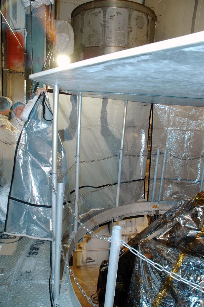 KENNEDY SPACE CENTER, FLA. --  Inside the mobile service tower on Launch Pad 17-B at Cape Canaveral Air Force Station,  workers inside the mobile service tower on Launch Pad 17-B at Cape Canaveral Air Force Station erect a protective screen above the THEMIS spacecraft to preserve a clean-room environment. THEMIS consists of five identical probes, the largest number of scientific satellites ever launched into orbit aboard a single rocket. The THEMIS mission is to investigate what causes auroras in the Earth's atmosphere to dramatically change from slowly shimmering waves of light to wildly shifting streaks of color. Discovering what causes auroras to change will provide scientists with important details on how the planet's magnetosphere works and the important Sun-Earth connection.  THEMIS is scheduled to launch aboard a Delta II rocket on Feb. 15 during a window extending from 6:08 to 6:27 p.m.  Photo credit: NASA/Amanda Diller