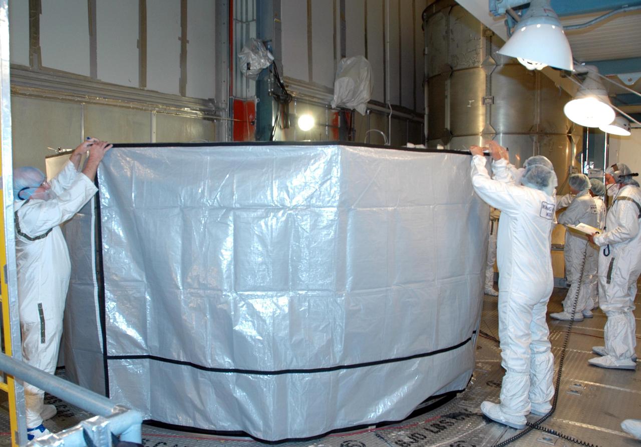 KENNEDY SPACE CENTER, FLA. --  Inside the mobile service tower on Launch Pad 17-B at Cape Canaveral Air Force Station, workers inside the mobile service tower on Launch Pad 17-B at Cape Canaveral Air Force Station complete installation of a protective screen above the THEMIS spacecraft to preserve a clean-room environment. THEMIS consists of five identical probes, the largest number of scientific satellites ever launched into orbit aboard a single rocket. The THEMIS mission is to investigate what causes auroras in the Earth's atmosphere to dramatically change from slowly shimmering waves of light to wildly shifting streaks of color. Discovering what causes auroras to change will provide scientists with important details on how the planet's magnetosphere works and the important Sun-Earth connection.  THEMIS is scheduled to launch aboard a Delta II rocket on Feb. 15 during a window extending from 6:08 to 6:27 p.m.  Photo credit: NASA/Amanda Diller