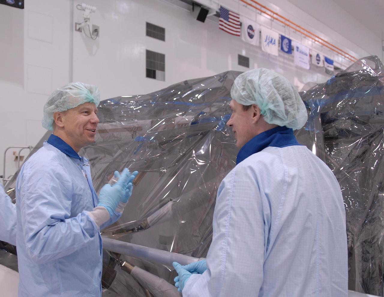 KENNEDY SPACE CENTER, FLA. --   Astronauts Tim Kopra (left) and Frank DeWinne share impressions of the Node 2 module in the Space Station Processing Facility.  They and other astronauts are familiarizing themselves with the various elements to be installed on the International Space Station on future spaceflights.  With construction of the Space Station the primary focus of future shuttle missions, astronaut crews will be working with one or more of the elements and hardware already being processed in the SSPF.  Photo credit: NASA/Kim Shiflett