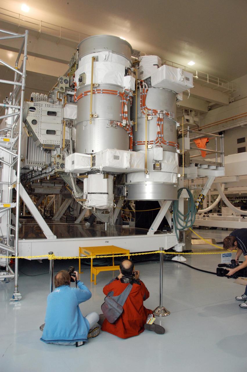 KENNEDY SPACE CENTER, FLA. --    In the Space Station Processing Facility, photographers take advantage of a media showcase to get photos of the S3/S4 integrated truss segment. The starboard 3/4 truss segment will launch aboard Space Shuttle Atlantis on mission STS-117, targeted for March 15.  The element will be added to the 11-segment integrated truss structure, the station's backbone. The integrated truss structure eventually will span more than 300 feet. The S3/S4 truss has two large solar arrays and will provide one-fourth of the total power generation for the completed station.  Photo credit: NASA/George Shelton