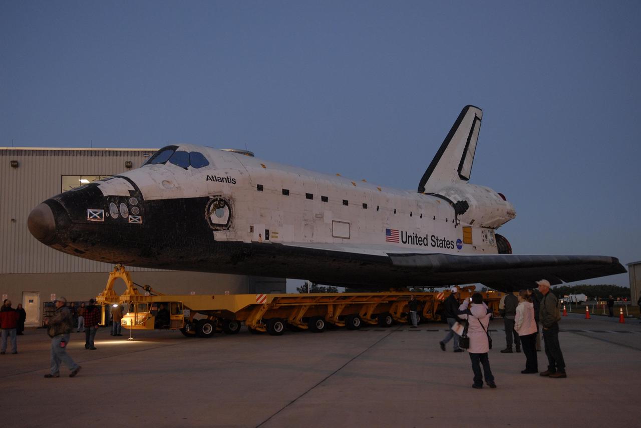 KENNEDY SPACE CENTER, FLA. --  The orbiter Atlantis , on top of its transporter, turns the corner from the Orbiter Processing Facility on its way to the Vehicle Assembly Building.  First motion out of OPF was at 6:19 a.m. EST.  Once in the VAB, Atlantis will be lifted into high bay 1 and mated with the external tank and solid rocket boosters already in place on the mobile launcher platform. The rollover signals the start of the journey to the launch pad for liftoff on mission STS-117 targeted for March 15.  The mission is the 21st to the International Space Station and will deliver the S3/S4 starboard truss segments.  Photo credit: NASA/Kim Shiflett
