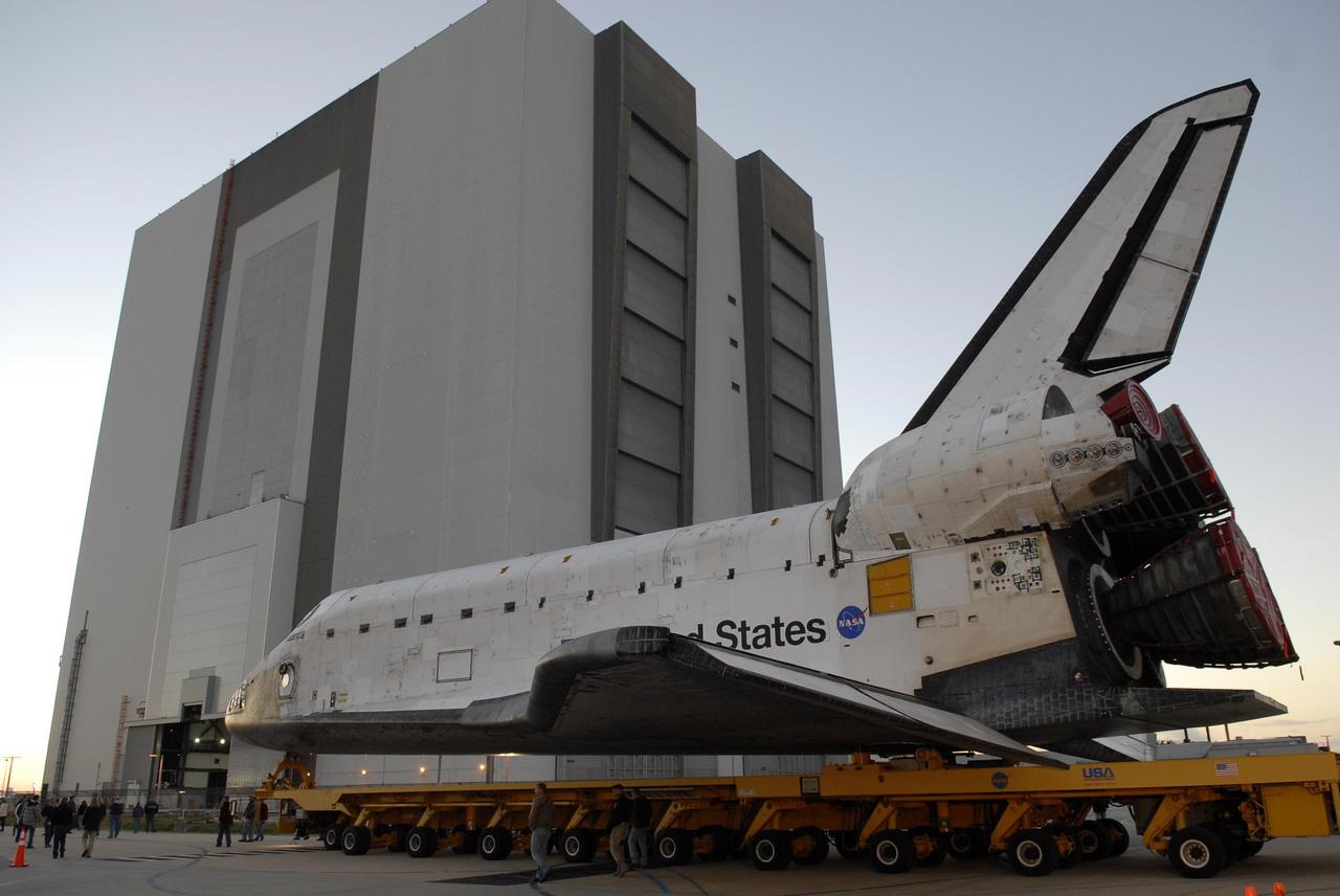 KENNEDY SPACE CENTER, FLA. --  The orbiter Atlantis, on top of its transporter, heads for the Vehicle Assembly Building (behind it) after leaving the Orbiter Processing Facility.  First motion out of OPF was at 6:19 a.m. EST.  Once in the VAB, Atlantis will be lifted into high bay 1 and mated with the external tank and solid rocket boosters already in place on the mobile launcher platform. The rollover signals the start of the journey to the launch pad for liftoff on mission STS-117 targeted for March 15.  The mission is the 21st to the International Space Station and will deliver the S3/S4 starboard truss segments.  Photo credit: NASA/Kim Shiflett