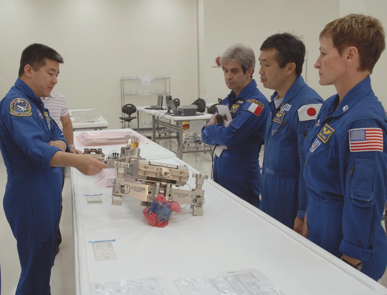 KENNEDY SPACE CENTER, FLA. --  In the Space Station Processing Facility, (left to right) astronauts Dan Tani, Leopold Eyharts, Koichi Wakata and Peggy Whitson study hardware for an upcoming shuttle flight. With construction of the Space Station the primary focus of future shuttle missions, astronaut crews will be working with one or more of the elements and hardware already being processed in the SSPF.  Photo credit: NASA/Kim Shiflett