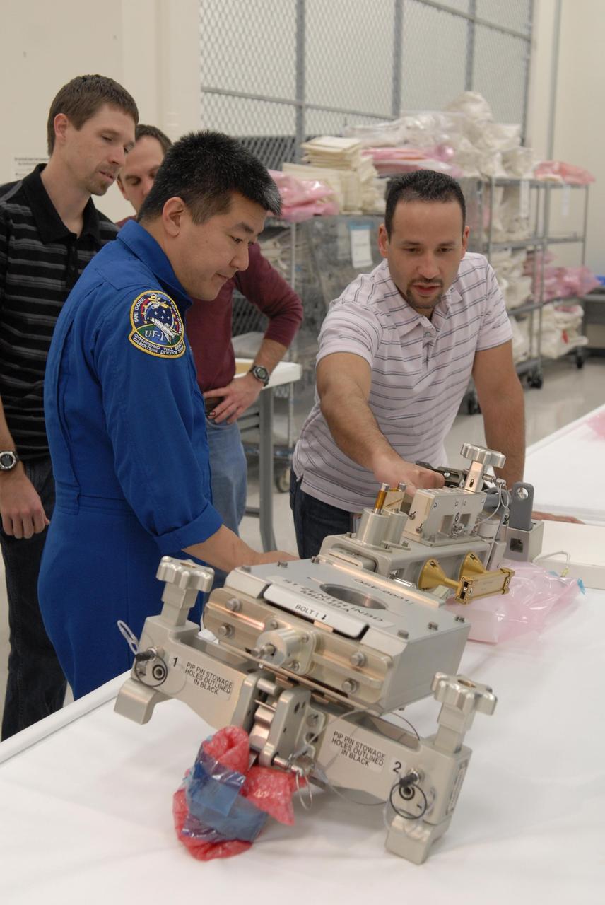 KENNEDY SPACE CENTER, FLA. --  In the Space Station Processing Facility, astronaut Dan Tani learns from a technician about the hardware on the table.  The hardware will be flown on an upcoming shuttle flight.   With construction of the Space Station the primary focus of future shuttle missions, astronaut crews will be working with one or more of the elements and hardware already being processed in the SSPF.  Photo credit: NASA/Kim Shiflett