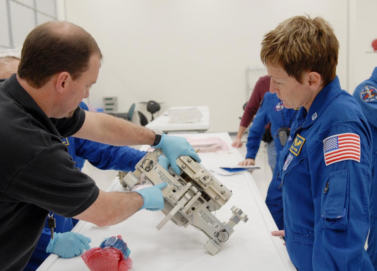 KENNEDY SPACE CENTER, FLA. -- In the Space Station Processing Facility, astronaut Peggy Whitson learns about the hardware the technician is holding. The hardware will be flown on an upcoming shuttle flight. With construction of the Space Station the primary focus of future shuttle missions, astronaut crews will be working with one or more of the elements and hardware already being processed in the SSPF. Photo credit: NASA/Kim Shiflett