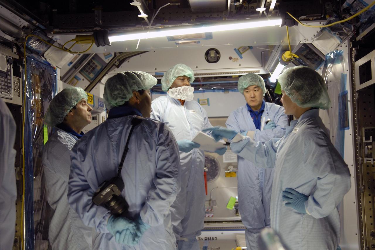 KENNEDY SPACE CENTER, FLA. --    In the Space Station Processing Facility, astronauts get data on the space station module they are in.  At left is Leopold Eyharts; at right is Dan Tani and Peggy Whitson.  With construction of the Space Station the primary focus of future shuttle missions, astronaut crews will be working with one or more of the elements and hardware already being processed in the SSPF.  Photo credit: NASA/Kim Shiflett
