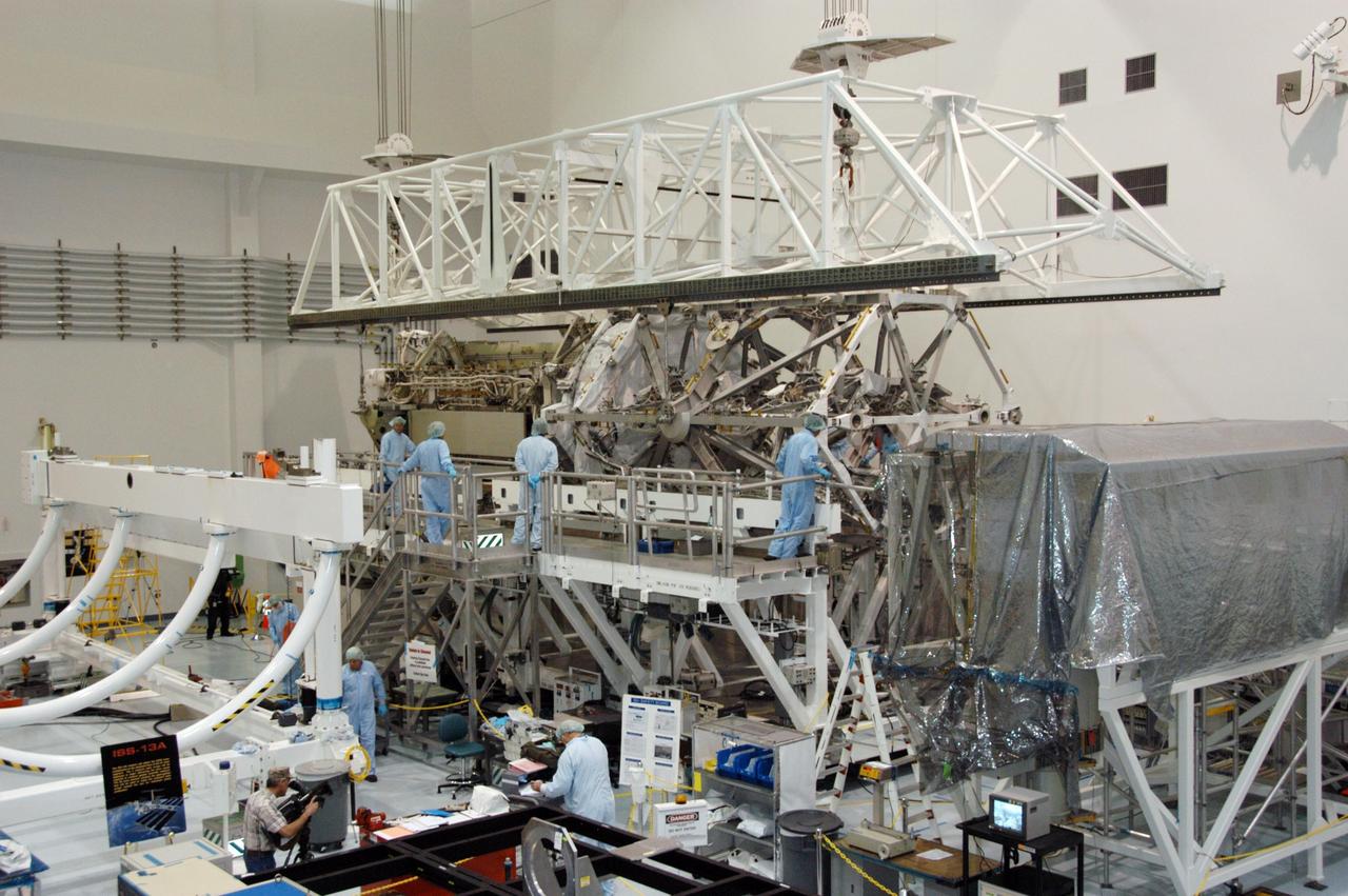 KENNEDY SPACE CENTER, FLA. -- In the Space Station Processing Facility, workers attach an overhead crane to the S3/S4 integrated truss in order to move it to the payload canister. After it is stowed in the canister, the S3/S4 truss will be transported to the launch pad.  The truss is the payload on mission STS-117, targeted for launch on March 15.   Photo credit: NASA/George Shelton