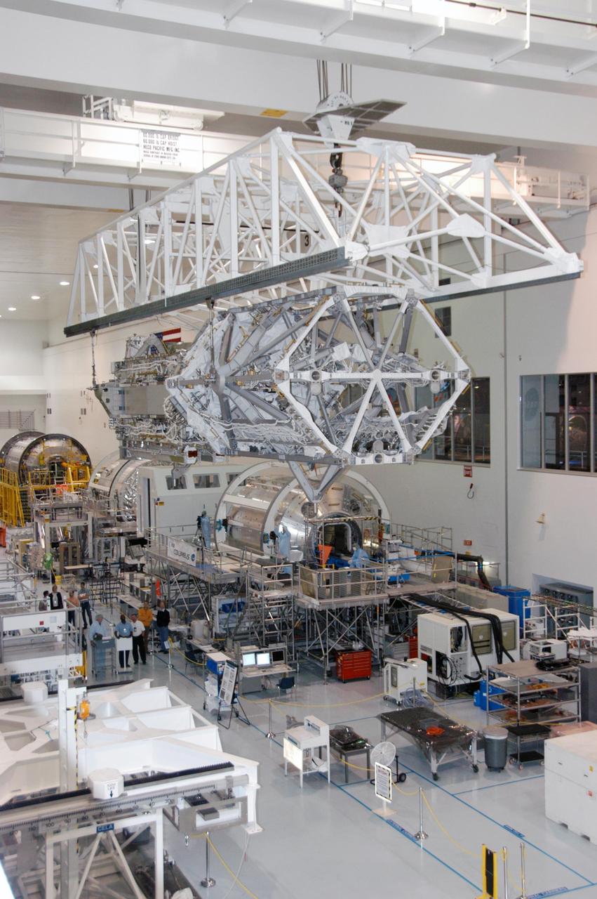 KENNEDY SPACE CENTER, FLA. --   In the Space Station Processing Facility, an overhead crane moves the S3/S4 integrated truss above the floor to a payload canister.  Several space station modules can be seen at various points on the floor.  After it is stowed in the canister, the S3/S4 truss will be transported to the launch pad.  The truss is the payload on mission STS-117, targeted for launch on March 15.   Photo credit: NASA/George Shelton