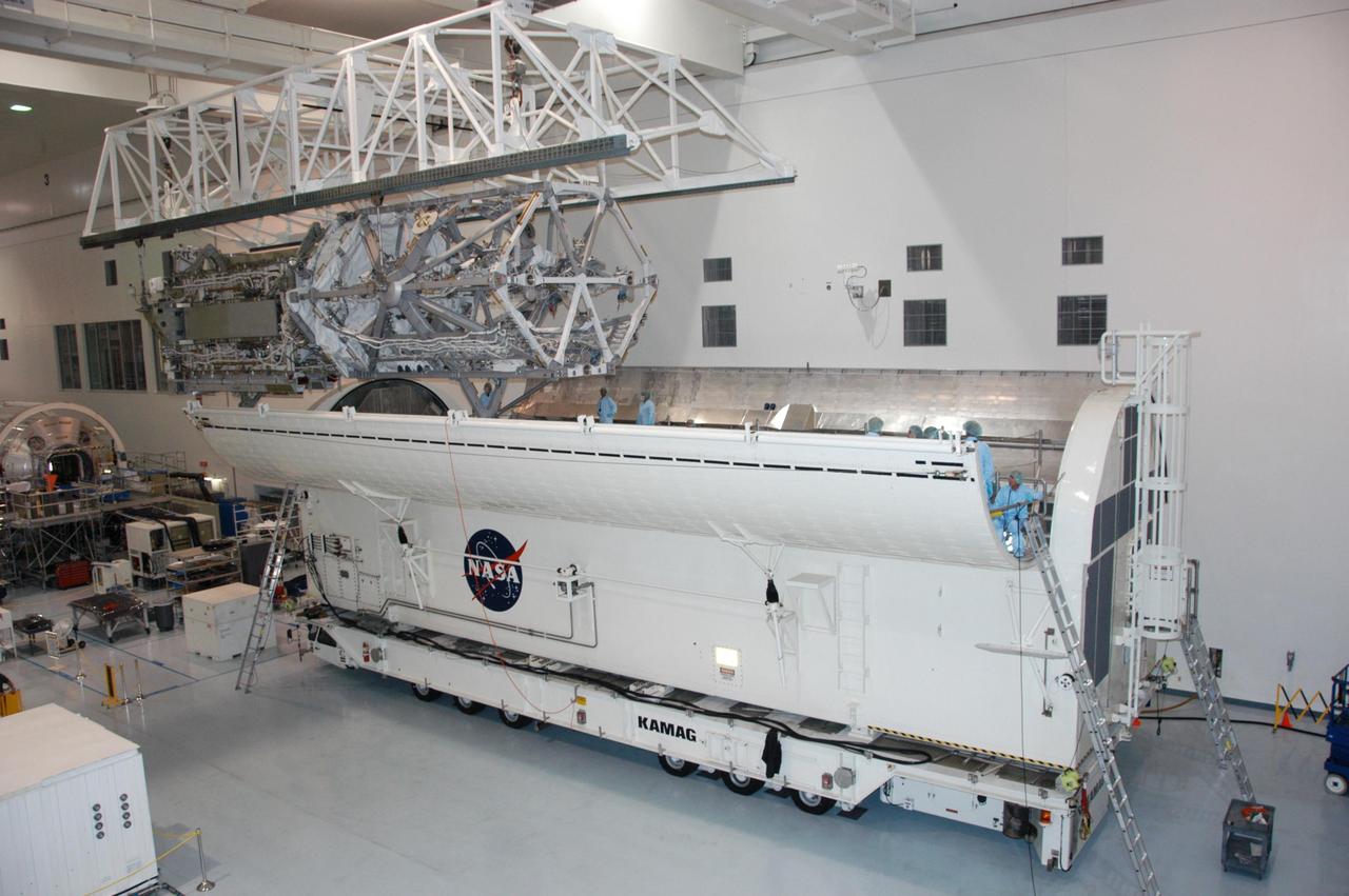 KENNEDY SPACE CENTER, FLA. --    In the Space Station Processing Facility, an overhead crane moves the S3/S4 integrated truss toward the open doors of the payload canister.  After it is stowed in the canister, the S3/S4 truss will be transported to the launch pad.  The truss is the payload on mission STS-117, targeted for launch on March 15.   Photo credit: NASA/George Shelton