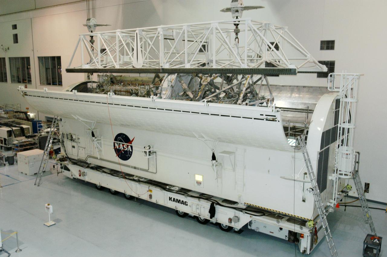 KENNEDY SPACE CENTER, FLA. --   In the Space Station Processing Facility, an overhead crane lowers the S3/S4 integrated truss into the open bay of the payload canister.  After it is stowed in the canister, the S3/S4 truss will be transported to the launch pad.  The truss is the payload on mission STS-117, targeted for launch on March 15.   Photo credit: NASA/George Shelton