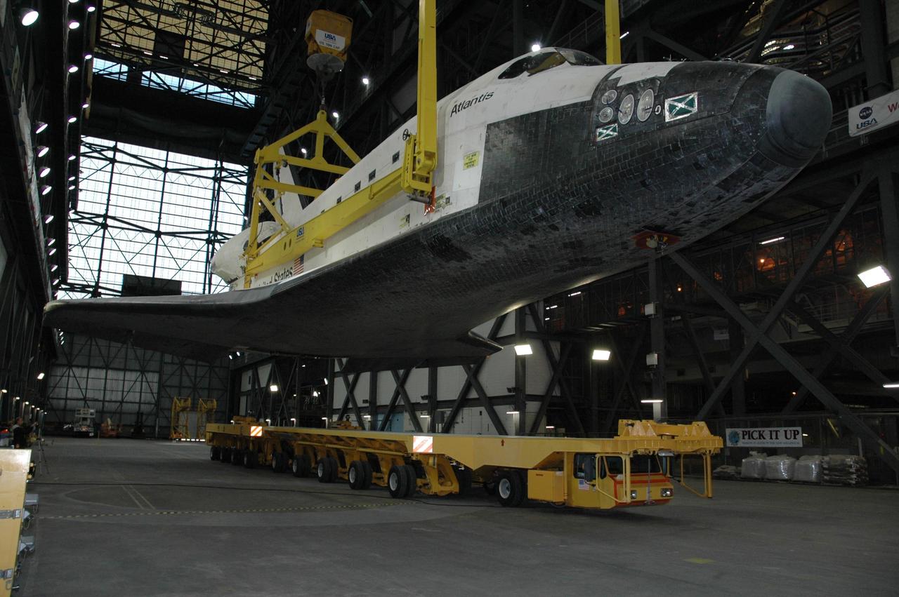 KENNEDY SPACE CENTER, FLA. --  In the transfer aisle of the Vehicle Assembly Building, the overhead sling lifts the orbiter Atlantis off the transporter. The orbiter will be raised to vertical and lifted up into high bay 1.  Then it will be lowered onto the mobile launcher platform where the external tank and solid rocket boosters are already stacked.  Space Shuttle Atlantis is targeted to roll out to Launch Pad 39A on February 14 for mission STS-117. The mission is No. 21 to the International Space Station and construction flight 13A. Photo credit: NASA/Amanda Diller