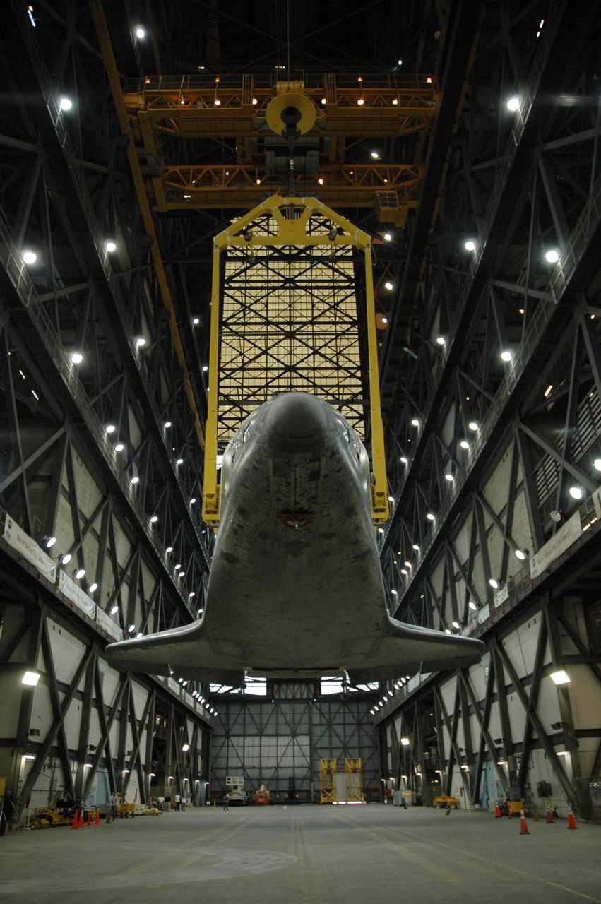 KENNEDY SPACE CENTER, FLA. -- In the transfer aisle of the Vehicle Assembly Building, the orbiter Atlantis is suspended by a sling. With the transporter moved away, the orbiter will be raised to vertical and lifted up into high bay 1. Then it will be lowered onto the mobile launcher platform where the external tank and solid rocket boosters are already stacked. Space Shuttle Atlantis is targeted to roll out to Launch Pad 39A on February 14 for mission STS-117. The mission is No. 21 to the International Space Station and construction flight 13A. Photo credit: NASA/Amanda Diller