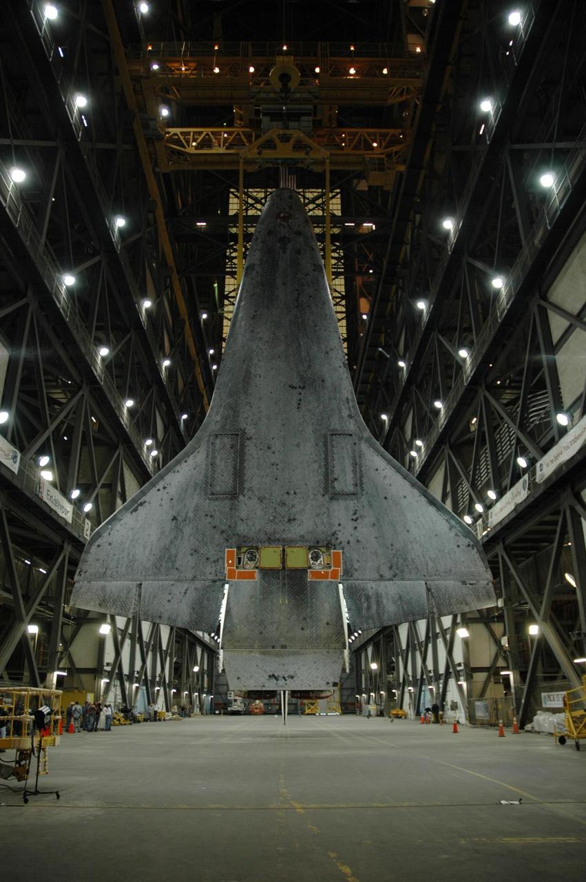 KENNEDY SPACE CENTER, FLA. --  The belly of Atlantis can be seen as the orbiter is suspended vertically above the transfer aisle of the Vehicle Assembly Building.  It will be lifted up into high bay 1 and lowered onto the mobile launcher platform where the external tank and solid rocket boosters are already stacked.  Space Shuttle Atlantis is targeted to roll out to Launch Pad 39A on February 14 for mission STS-117. The mission is No. 21 to the International Space Station and construction flight 13A. Photo credit: NASA/Amanda Diller