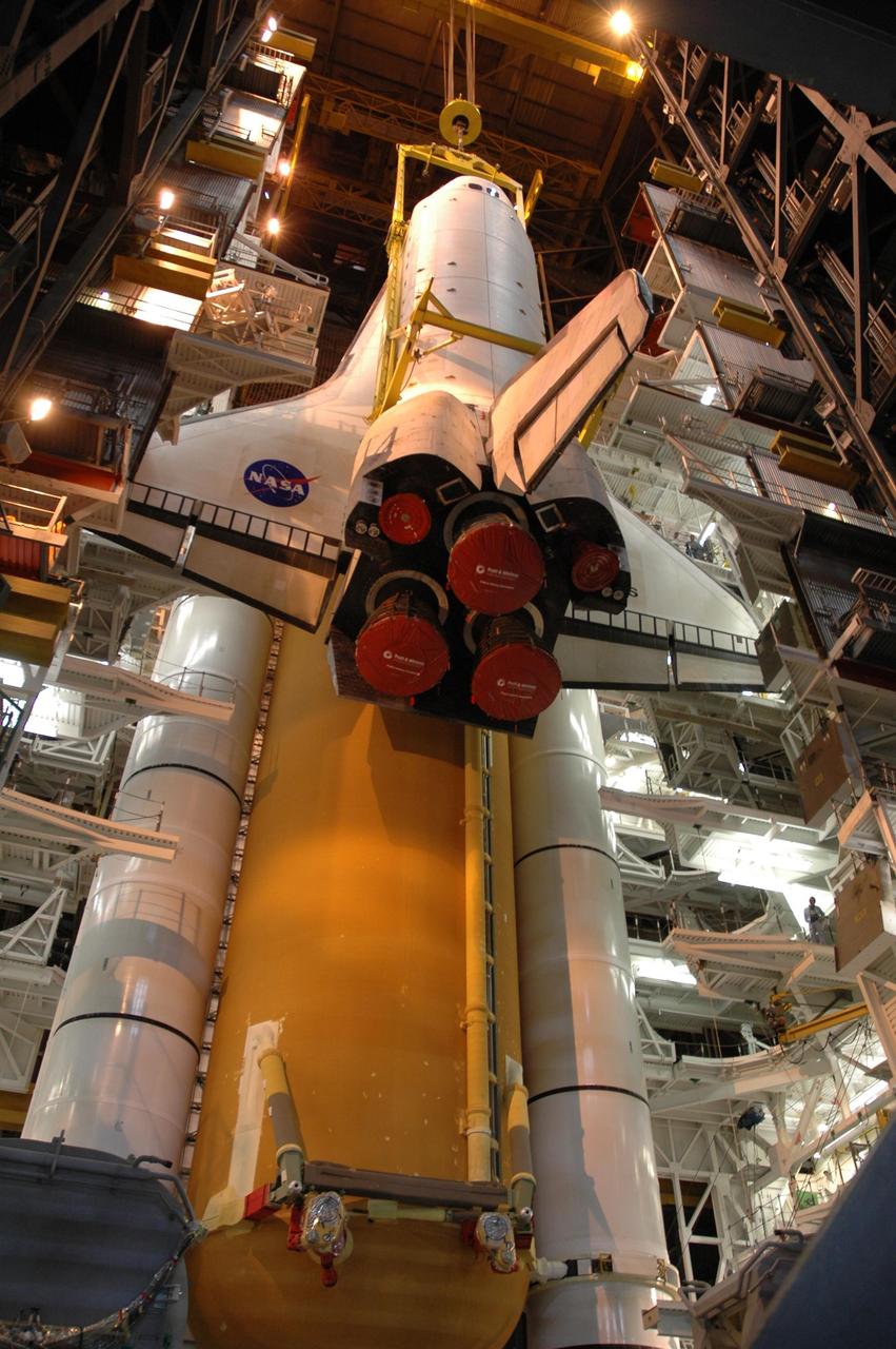 KENNEDY SPACE CENTER, FLA. --  The overhead sling lowers the orbiter Atlantis next to the external tank and solid rocket boosters stacked on the mobile launcher platform (MLP) below.  Atlantis will be mated to the MLP  as well. Space Shuttle Atlantis is targeted to roll out to Launch Pad 39A on February 14 for mission STS-117. The mission is No. 21 to the International Space Station and construction flight 13A. Photo credit: NASA/Amanda Diller