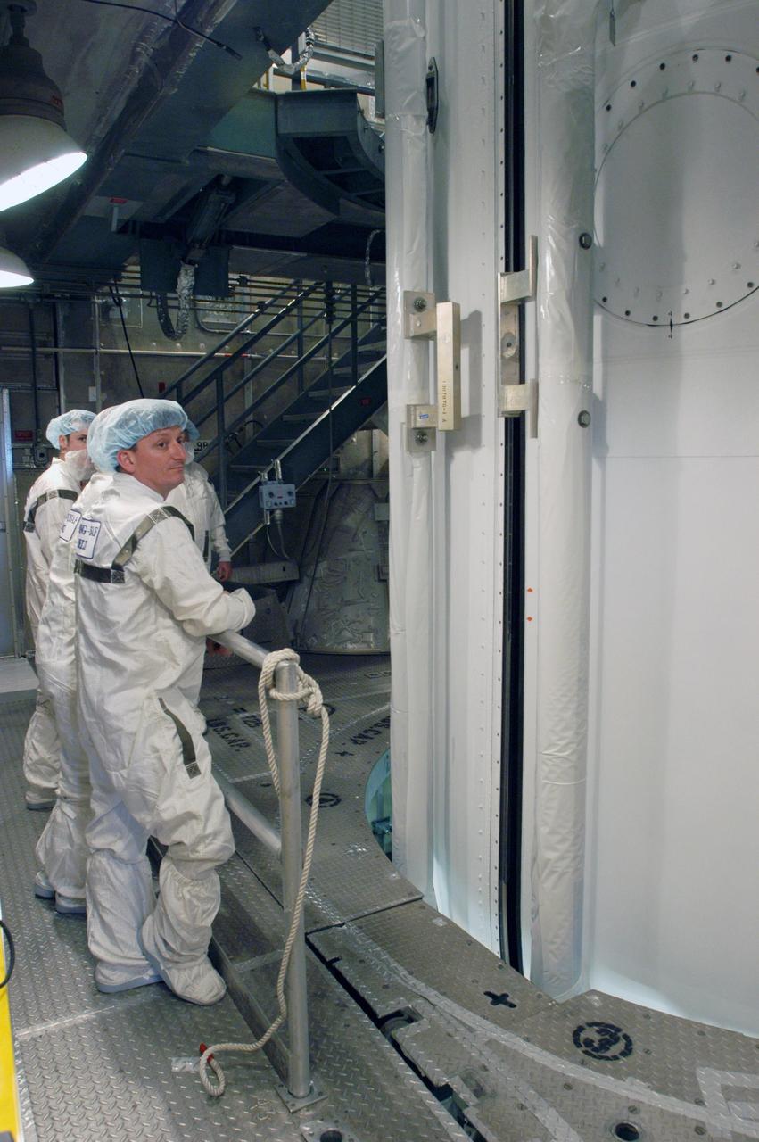 KENNEDY SPACE CENTER, FLA. --  In the mobile service tower on Pad 17-B at Cape Canaveral Air Force Station, the two fairing segments come together around the THEMIS spacecraft.  The fairing is a molded structure that fits flush with the outside surface of the Delta II upper stage booster and forms an aerodynamically smooth nose cone, protecting the spacecraft during launch and ascent.  THEMIS is an acronym for Time History of Events and Macroscale Interactions during Substorms.  THEMIS consists of five identical probes that will track violent, colorful eruptions near the North Pole.  This will be the largest number of scientific satellites NASA ever launched into orbit aboard a single rocket.  The THEMIS mission aims to unravel the tantalizing mystery behind auroral substorms, an avalanche of magnetic energy powered by the solar wind that intensifies the northern and southern lights.  The mission will investigate what causes auroras in the Earth’s atmosphere to dramatically change from slowly shimmering waves of light to wildly shifting streaks of bright color.  Launch of THEMIS is scheduled for Feb. 15 aboard a Delta II rocket, with the launch service being conducted by the United Launch Alliance.  Photo credit: NASA/George Shelton