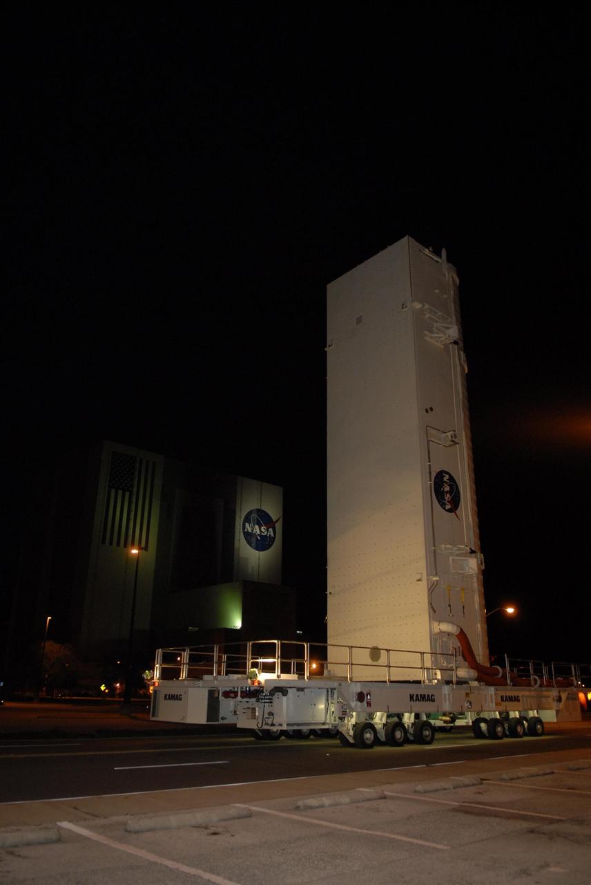 KENNEDY SPACE CENTER, FLA. -- The payload canister on its transporter passes the Vehicle Assembly Building at NASA's Kennedy Space Center, heading for Launch Pad 39A. The canister contains the S3/S4 integrated truss for mission STS-117 to the International Space Station aboard Space Shuttle Atlantis. The Atlantis crew will install the new truss segment, retract a set of solar arrays and unfold a new set on the starboard side of the station. Launch is targeted for March 15. Photo credit: NASA/Kim Shiflett