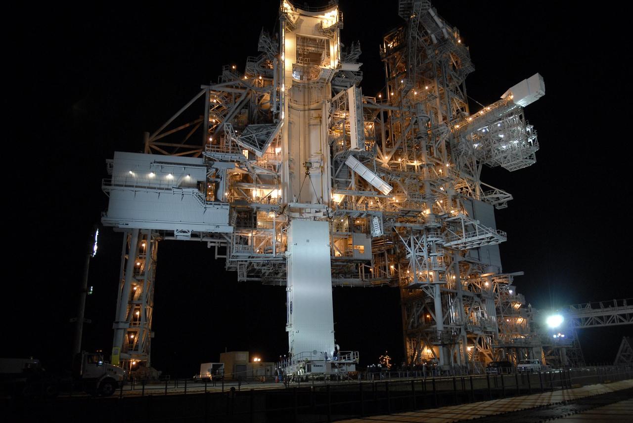KENNEDY SPACE CENTER, FLA. --  The payload canister on its transporter arrives on Launch Pad 39A, stopping beneath the payload changeout room on the rotating service structure (RSS).  The canister contains the S3/S4 integrated truss for mission STS-117 to the International Space Station aboard Space Shuttle Atlantis. Once inside the PCR, the S3/S4 arrays will be transferred into Space Shuttle Atlantis' payload bay after the vehicle has rolled out to the pad.  The changeout room is the enclosed, environmentally controlled portion of the RSS that supports cargo delivery to the pad and subsequent vertical installation into the orbiter payload bay.The Atlantis crew will install the new truss segment, retract a set of solar arrays and unfold a new set on the starboard side of the station. Launch is targeted for March 15.  Photo credit: NASA/Kim Shiflett