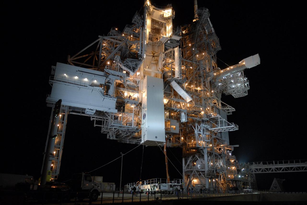KENNEDY SPACE CENTER, FLA. --  With umbilical lines still attached, the payload canister is lifted up to the payload changeout room on the rotating service structure (RSS) on Launch Pad 39A The canister contains the S3/S4 integrated truss for mission STS-117 to the International Space Station aboard Space Shuttle Atlantis. Once inside the PCR, the S3/S4 arrays will be transferred into Space Shuttle Atlantis' payload bay after the vehicle has rolled out to the pad.  The changeout room is the enclosed, environmentally controlled portion of the RSS that supports cargo delivery to the pad and subsequent vertical installation into the orbiter payload bay. The Atlantis crew will install the new truss segment, retract a set of solar arrays and unfold a new set on the starboard side of the station. Launch is targeted for March 15.  Photo credit: NASA/Kim Shiflett