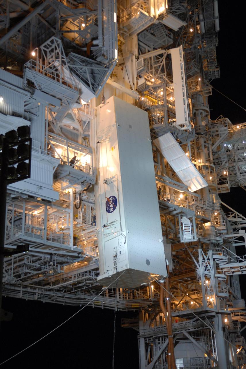 KENNEDY SPACE CENTER, FLA. --  With umbilical lines still attached, the payload canister is lifted up to the payload changeout room on the rotating service structure (RSS) on Launch Pad 39A The canister contains the S3/S4 integrated truss for mission STS-117 to the International Space Station aboard Space Shuttle Atlantis. Once inside the PCR, the S3/S4 arrays will be transferred into Space Shuttle Atlantis' payload bay after the vehicle has rolled out to the pad.  The changeout room is the enclosed, environmentally controlled portion of the RSS that supports cargo delivery to the pad and subsequent vertical installation into the orbiter payload bay. The Atlantis crew will install the new truss segment, retract a set of solar arrays and unfold a new set on the starboard side of the station. Launch is targeted for March 15.  Photo credit: NASA/Kim Shiflett