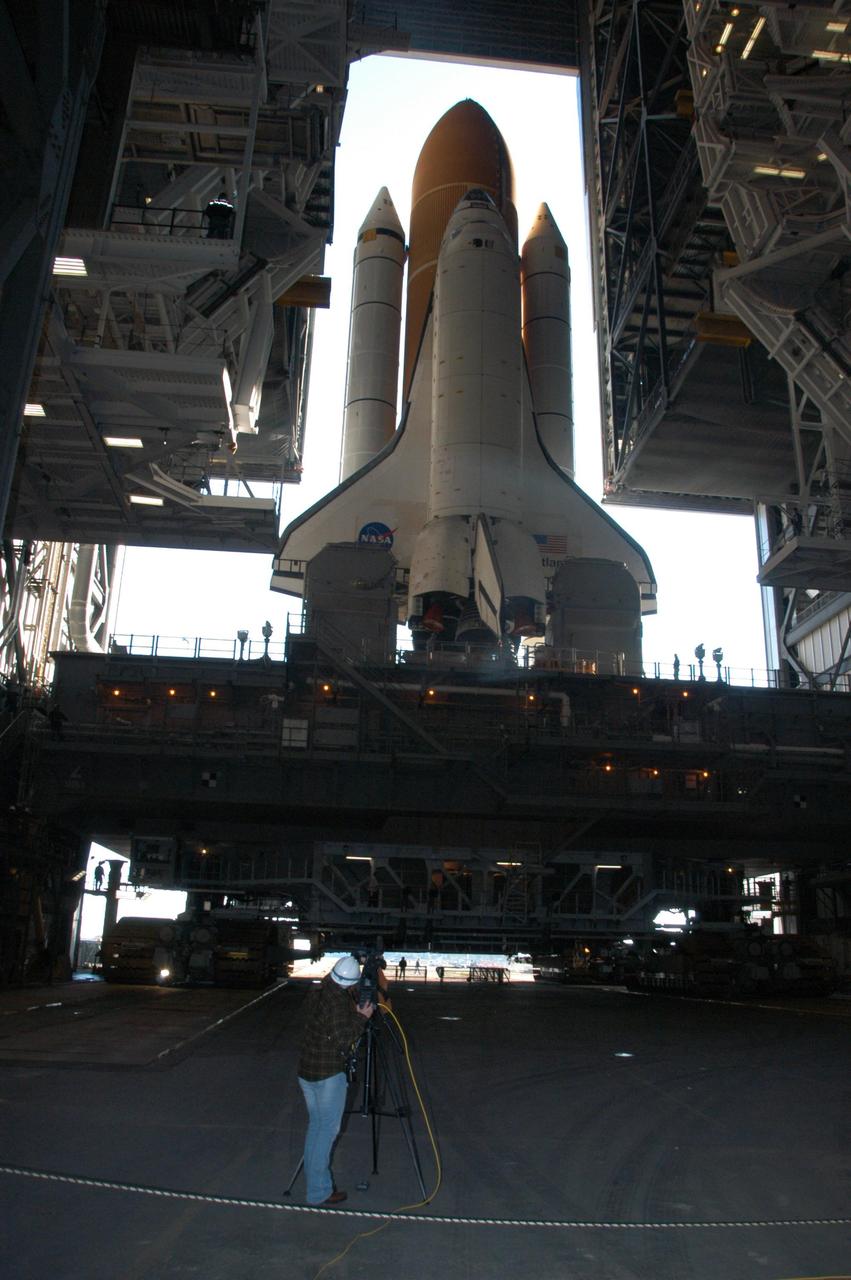 KENNEDY SPACE CENTER, FLA. -- Atop the massive mobile launcher platform and crawler-transporter, Space Shuttle Atlantis begins rolling through the open door of the Vehicle Assembly Building for the journey to Launch Pad 39A. First motion was at 8:19 a.m. In front of each of Atlantis' wings are the tail masts, which provide several umbilical connections to the orbiter, including a liquid-oxygen line through one and a liquid-hydrogen line through another. The 3.4-mile trip to the pad along the crawlerway will take about 6 hours. The mission payload aboard Space Shuttle Atlantis is the S3/S4 integrated truss structure, along with a third set of solar arrays and batteries. The crew of six astronauts will install the truss to continue assembly of the International Space Station. Launch is targeted for March 15. Photo credit: NASA/George Shelton
