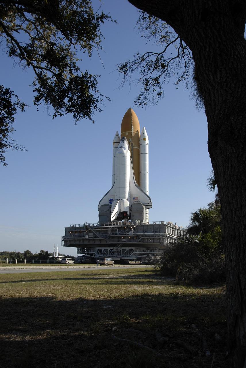 KENNEDY SPACE CENTER, FLA. -- Sunlight bathes Space Shuttle Atlantis and oak Leaves frame the image as the shuttle moves slowly toward Launch Pad 39A. First motion out of the Vehicle Assembly Building was at 8:19 a.m. The 3.4-mile trip to the pad along the crawlerway will take about 6 hours. The mission payload aboard Space Shuttle Atlantis is the S3/S4 integrated truss structure, along with a third set of solar arrays and batteries. The crew of six astronauts will install the truss to continue assembly of the International Space Station. Launch is targeted for March 15. Photo credit: NASA/Kim Shiflett
