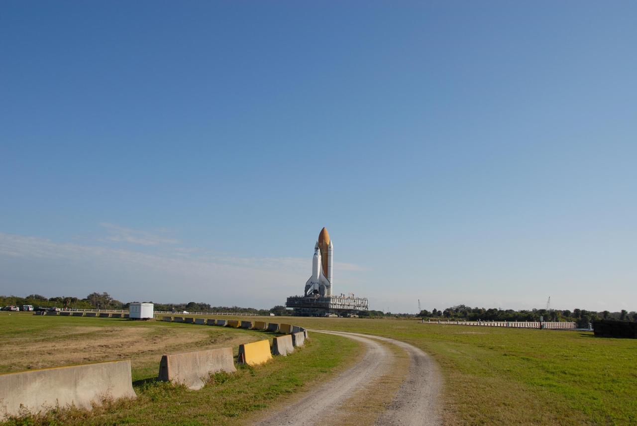 KENNEDY SPACE CENTER, FLA. -- In the clear morning light, Space Shuttle Atlantis , atop the mobile launcher platform and crawler-transporter, slowly makes its way to Launch Pad 39A. First motion out of the Vehicle Assembly Building was at 8:19 a.m. The 3.4-mile trip to the pad along the crawlerway will take about 6 hours. The mission payload aboard Space Shuttle Atlantis is the S3/S4 integrated truss structure, along with a third set of solar arrays and batteries. The crew of six astronauts will install the truss to continue assembly of the International Space Station. Launch is targeted for March 15. Photo credit: NASA/Ken Thornsley