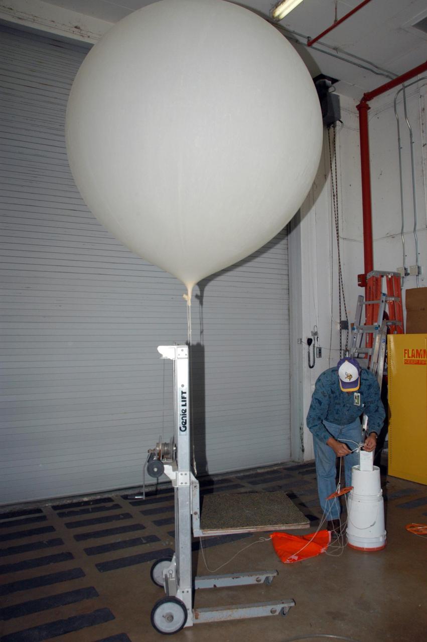 KENNEDY SPACE CENTER, FLA. -- A weather balloon is prepared for release at the Cape Canaveral Air Force Station weather station. The balloon is equipped with a radiosonde, an instrument that transmits measurements on atmospheric pressure, humidity, temperature and winds as it ascends. The data will be used to determine if conditions are acceptable for the launch of NASA's THEMIS mission. THEMIS, an acronym for Time History of Events and Macroscale Interactions during Substorms, consists of five identical probes that will track violent, colorful eruptions near the North Pole.  This will be the largest number of scientific satellites NASA has ever launched into orbit aboard a single rocket.  The THEMIS mission aims to unravel the mystery behind auroral substorms, an avalanche of magnetic energy powered by the solar wind that intensifies the northern and southern lights.  The mission will investigate what causes auroras in the Earth’s atmosphere to dramatically change from slowly shimmering waves of light to wildly shifting streaks of bright color. Launch is planned from Pad 17-B in a window that extends from 6:01 to 6:19 p.m. EST.  Photo credit: NASA/George Shelton