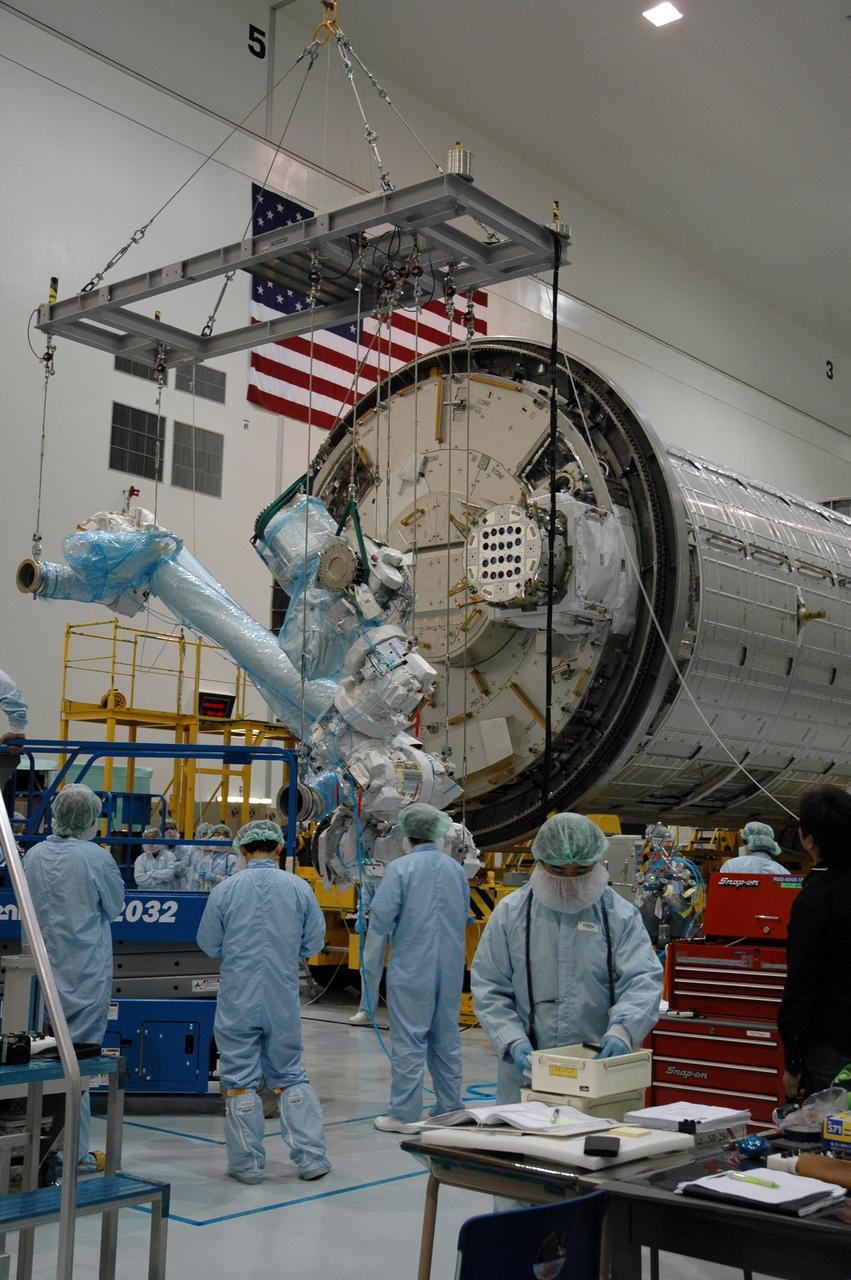 KENNEDY SPACE CENTER, FLA. -- Inside the Space Station Processing Facility at Kennedy Space Center, workers attach the Remote Manipulator System, or robotic arm, to the Japanese Experiment Module for testing. The RMS is one of the payloads scheduled to be delivered to the station on a future mission tentatively scheduled for 2008. The RMS is similar to the robotic arm already installed on the station's mobile base system. Photo credit: NASA/Amanda Diller