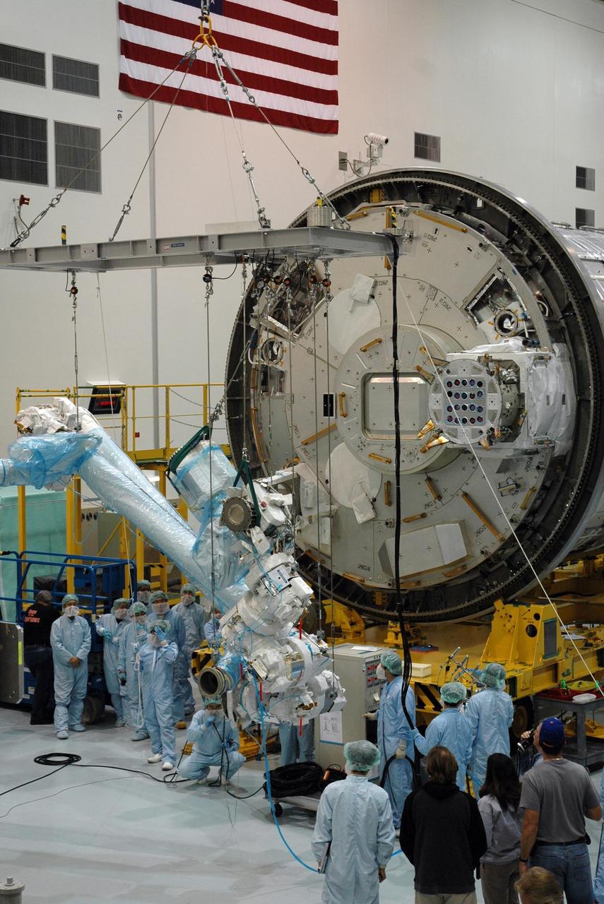 KENNEDY SPACE CENTER, FLA. -- Inside the Space Station Processing Facility at Kennedy Space Center, workers attach the Remote Manipulator System, or robotic arm, to the Japanese Experiment Module for testing. The RMS is one of the payloads scheduled to be delivered to the station on a future mission tentatively scheduled for 2008. The RMS is similar to the robotic arm already installed on the station's mobile base system. Photo credit: NASA/Amanda Diller