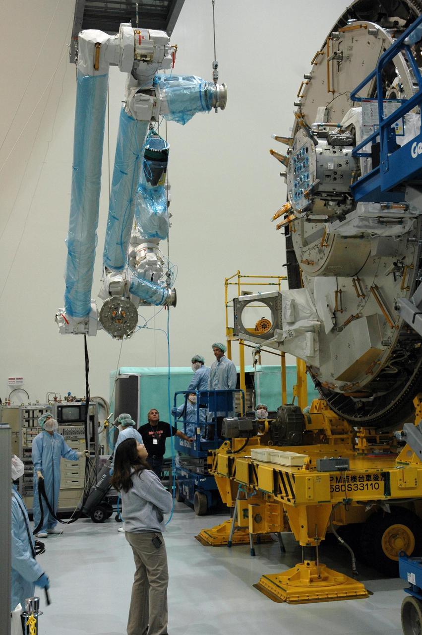 KENNEDY SPACE CENTER, FLA. -- Inside the Space Station Processing Facility at Kennedy Space Center, workers use a hoisting device to move the Remote Manipulator System, or robotic arm, toward the Japanese Experiment Module for installation and testing. The RMS is one of the payloads scheduled to be delivered to the station on a future mission tentatively scheduled for 2008.The RMS is similar to the robotic arm already installed on the station's mobile base system. Photo credit: NASA/Amanda Diller