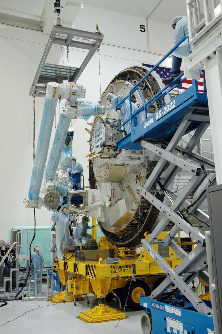 KENNEDY SPACE CENTER, FLA. -- Inside the Space Station Processing Facility at Kennedy Space Center, workers use a hoisting device to move the Remote Manipulator System, or robotic arm, toward the Japanese Experiment Module for installation and testing. The RMS is one of the payloads scheduled to be delivered to the station on a future mission tentatively scheduled for 2008.The RMS is similar to the robotic arm already installed on the station's mobile base system. Photo credit: NASA/Amanda Diller