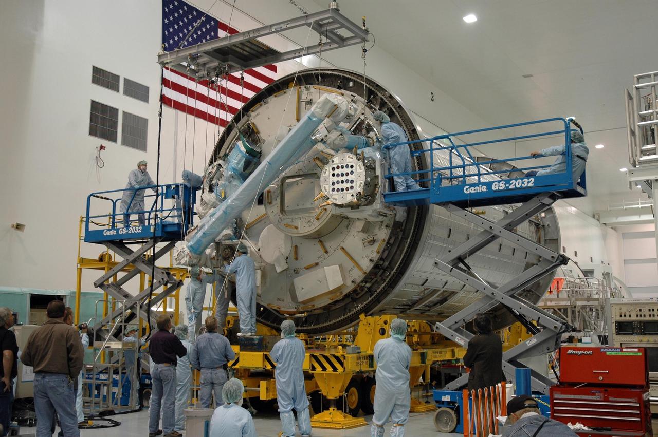 KENNEDY SPACE CENTER, FLA. -- Inside the Space Station Processing Facility at Kennedy Space Center, workers attach the Remote Manipulator System, or robotic arm, to the Japanese Experiment Module for testing. The RMS is one of the payloads scheduled to be delivered to the station on a future mission tentatively scheduled for 2008. The RMS is similar to the robotic arm already installed on the station's mobile base system. Photo credit: NASA/Amanda Diller