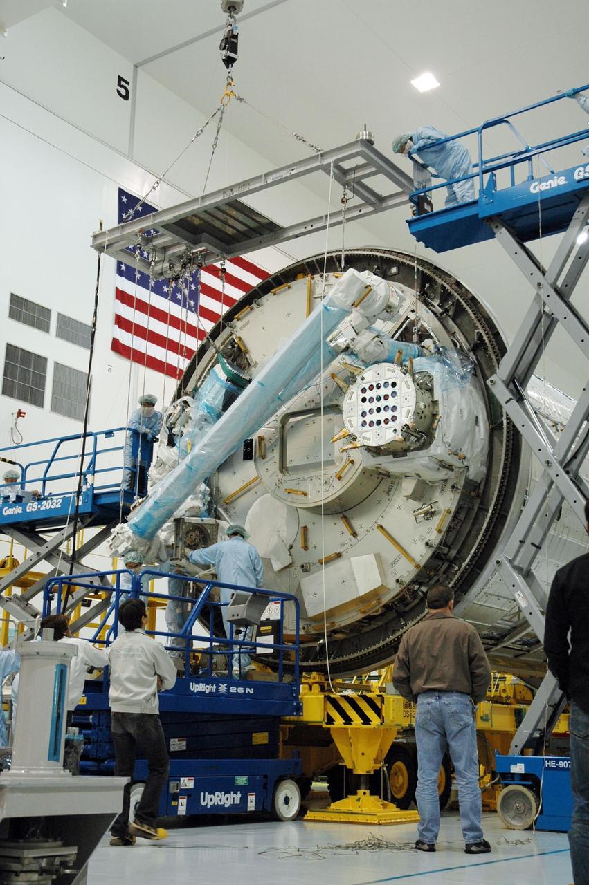 KENNEDY SPACE CENTER, FLA. -- Inside the Space Station Processing Facility at Kennedy Space Center, workers attach the Remote Manipulator System, or robotic arm, to the Japanese Experiment Module for testing. The RMS is one of the payloads scheduled to be delivered to the station on a future mission tentatively scheduled for 2008. The RMS is similar to the robotic arm already installed on the station's mobile base system. Photo credit: NASA/Amanda Diller