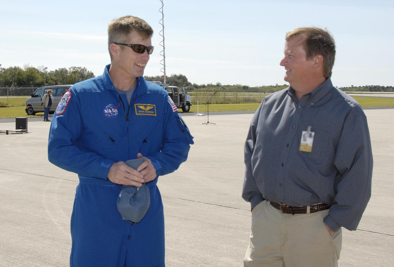 KENNEDY SPACE CENTER, FLA. -- The STS-117 crew arrives at NASA's Kennedy Space Center to take part in the Terminal Countdown Demonstration Test (TCDT), a preparation for the launch March 15 to the International Space Station. NASA Launch Director Mike Leinbach greets Mission Specialist Steven Swanson at the Shuttle Landing Facility. The TCDT includes emergency egress training and a simulated launch countdown. The mission payload aboard Space Shuttle Atlantis is the S3/S4 integrated truss structure, along with a third set of solar arrays and batteries. The crew of six astronauts will install the truss to continue assembly of the station. Photo credit: NASA/Kim Shiflett