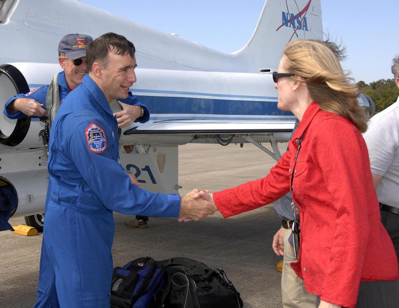 KENNEDY SPACE CENTER, FLA. -- The STS-117 crew arrives at NASA's Kennedy Space Center to take part in the Terminal Countdown Demonstration Test (TCDT), a preparation for the launch March 15 to the International Space Station. Atlantis (OV104) Flow Director Angela Brewer greets Pilot Lee Archambault after he arrives at the Shuttle Landing Facility. The TCDT includes emergency egress training and a simulated launch countdown. The mission payload aboard Space Shuttle Atlantis is the S3/S4 integrated truss structure, along with a third set of solar arrays and batteries. The crew of six astronauts will install the truss to continue assembly of the station. Photo credit: NASA/Kim Shiflett
