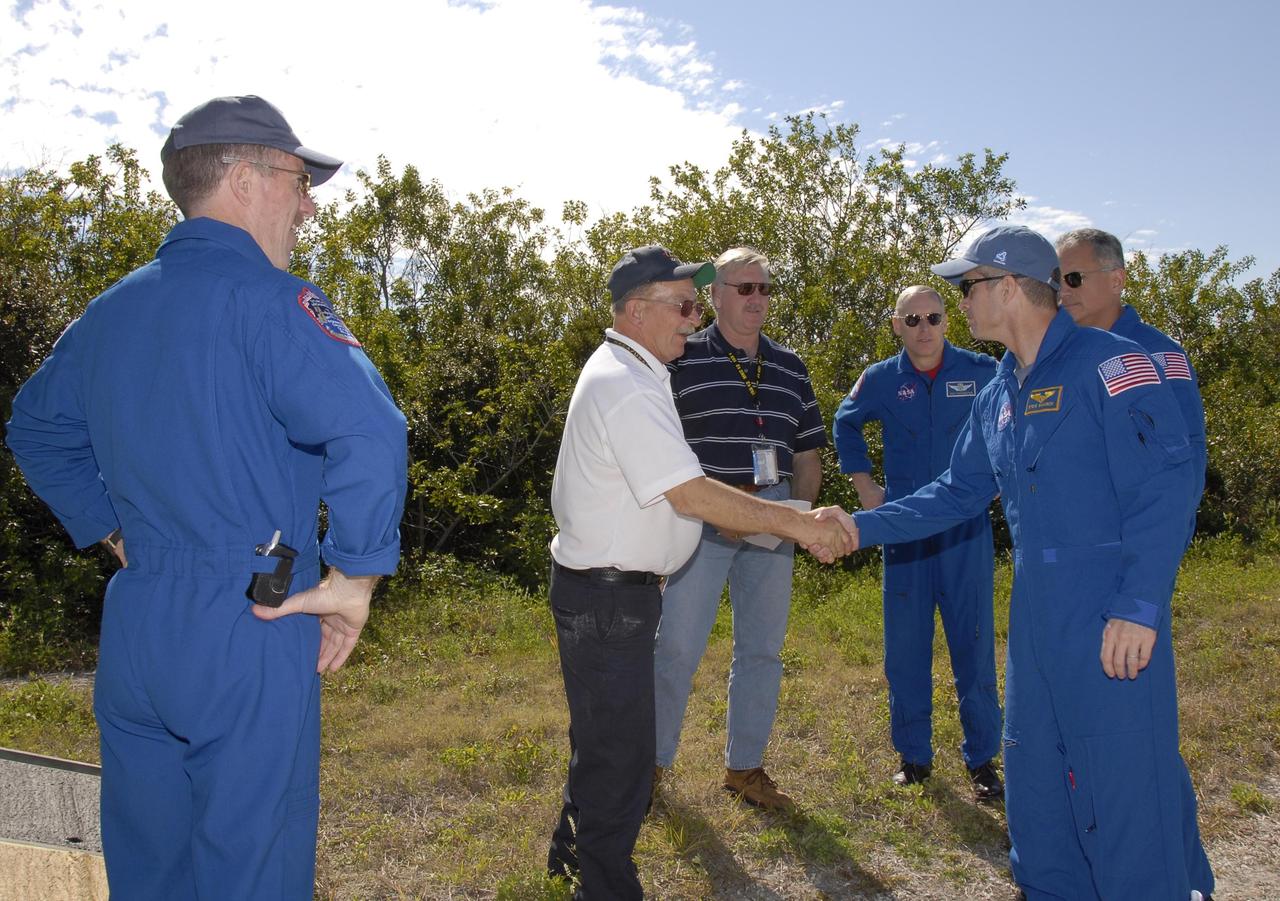 KENNEDY SPACE CENTER, FLA. -- At Launch Complex 39, astronaut rescue team leader Capt. George Hoggard, second from left, greets STS-117 Mission Specialist Steven Swanson as fellow crew members, from left, Mission Specialists James Reilly, Patrick Forrester and Danny Olivas look on. The astronauts on the STS-117 crew are participating in M-113 armored personnel carrier training during Terminal Countdown Demonstration Test (TCDT) activities, a dress rehearsal for their launch, targeted for March 15. The M-113 could be used to move the crew away from the launch pad quickly in the event of an emergency. The TCDT also includes pad emergency egress training and a simulated launch countdown. The mission payload aboard Space Shuttle Atlantis is the S3/S4 integrated truss structure, along with a third set of solar arrays and batteries. The crew of six astronauts will install the truss to continue assembly of the station. Photo credit: NASA/Kim Shiflett