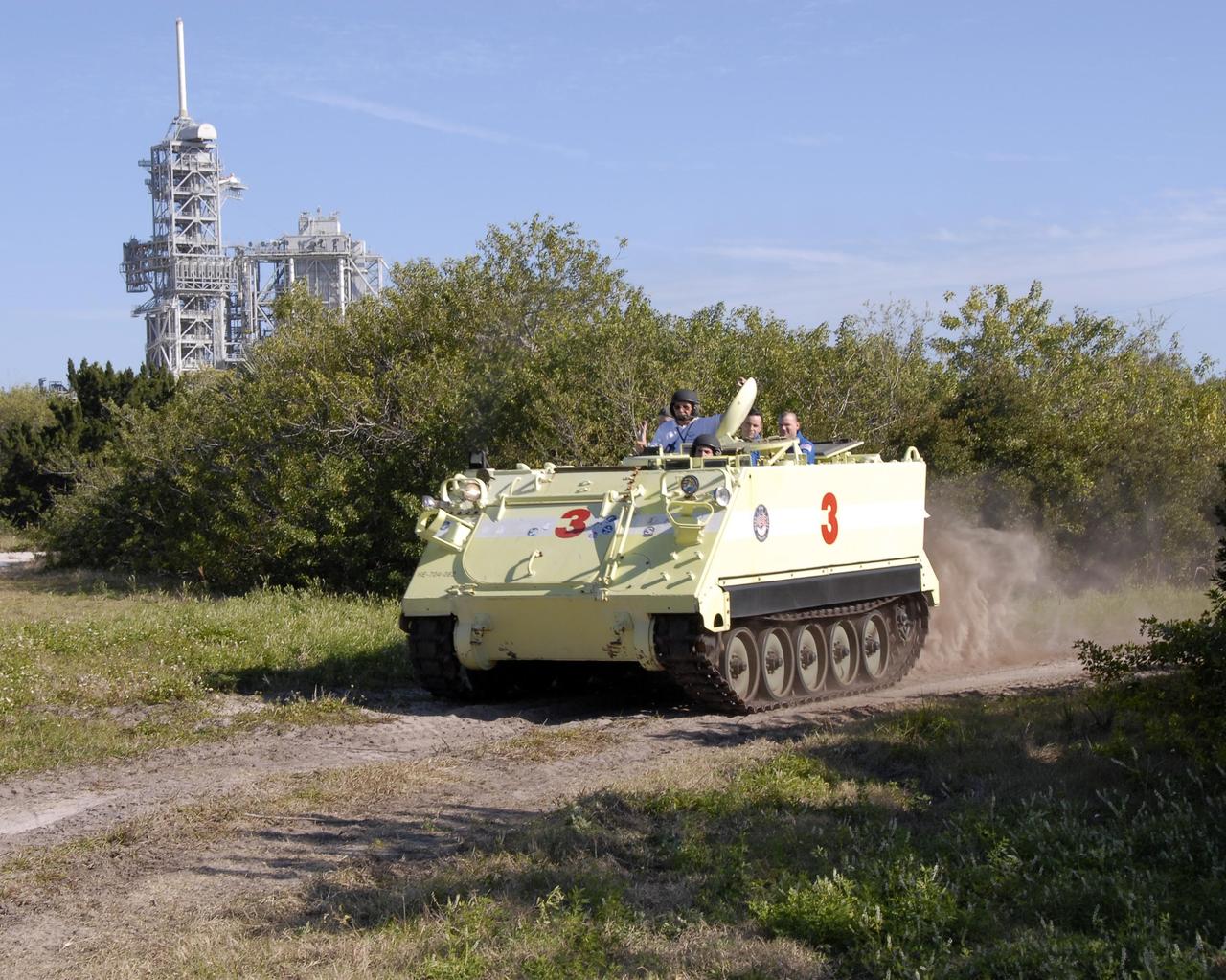 KENNEDY SPACE CENTER, FLA. -- At Launch Complex 39, members of the STS-117 crew are instructed in the operation of an M-113 armored personnel carrier by astronaut rescue team leader Capt. George Hoggard (left). The astronauts on the STS-117 crew are participating in M-113 armored personnel carrier training during Terminal Countdown Demonstration Test (TCDT) activities, a dress rehearsal for their launch, targeted for March 15. The M-113 could be used to move the crew away from the launch pad quickly in the event of an emergency. The TCDT also includes pad emergency egress training and a simulated launch countdown. The mission payload aboard Space Shuttle Atlantis is the S3/S4 integrated truss structure, along with a third set of solar arrays and batteries. The crew of six astronauts will install the truss to continue assembly of the station. Photo credit: NASA/Kim Shiflett