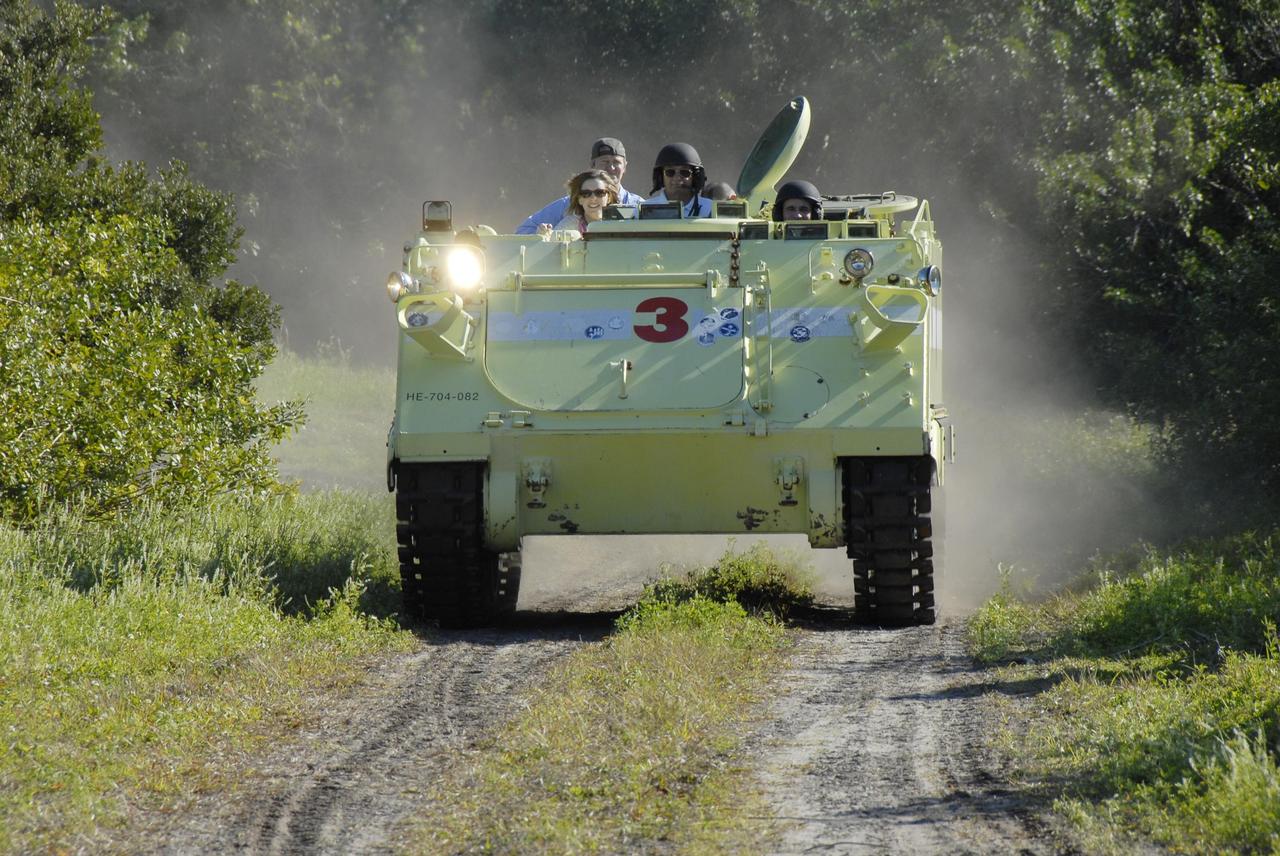 KENNEDY SPACE CENTER, FLA. -- At Launch Complex 39, members of the STS-117 crew are instructed in the operation of an M-113 armored personnel carrier by the astronaut rescue team. The astronauts on the STS-117 crew are participating in M-113 armored personnel carrier training during Terminal Countdown Demonstration Test (TCDT) activities, a dress rehearsal for their launch, targeted for March 15. The M-113 could be used to move the crew away from the launch pad quickly in the event of an emergency. The TCDT also includes pad emergency egress training and a simulated launch countdown. The mission payload aboard Space Shuttle Atlantis is the S3/S4 integrated truss structure, along with a third set of solar arrays and batteries. The crew of six astronauts will install the truss to continue assembly of the station. Photo credit: NASA/Kim Shiflett