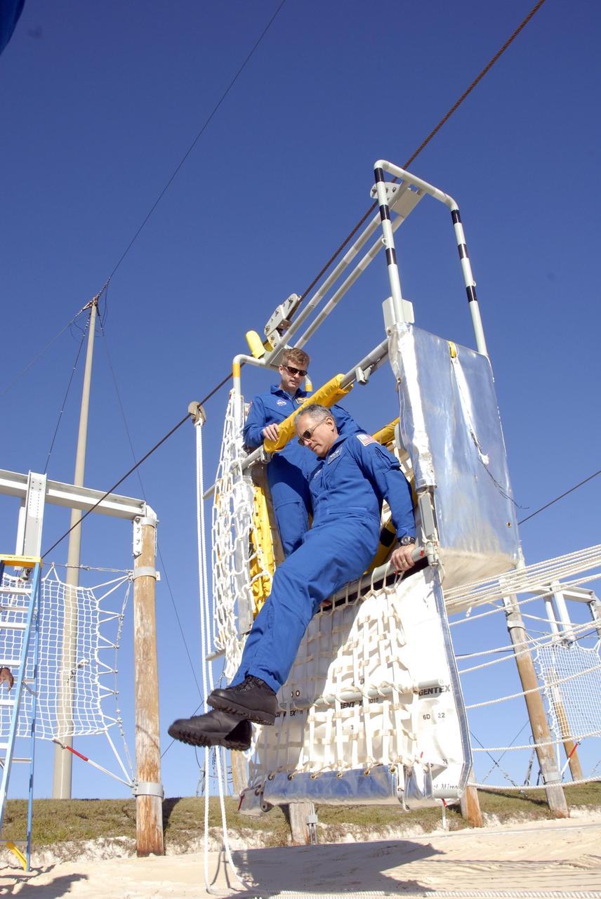 KENNEDY SPACE CENTER, FLA. --  In the Launch Pad 39A area, Mission STS-117 crew members receive instruction on emergency egress using the slidewire basket system during Terminal Countdown Demonstration Test activities. Here, Mission Specialists Steven Swanson (left) and Danny Olivas (right) practice exiting from the slidewire basket. The TCDT also includes M-113 armored personnel carrier training, and a simulated launch countdown. The mission payload aboard Space Shuttle Atlantis is the S3/S4 integrated truss structure, along with a third set of solar arrays and batteries. The crew of six astronauts will install the truss to continue assembly of the International Space Station. Photo credit: NASA/Kim Shiflett