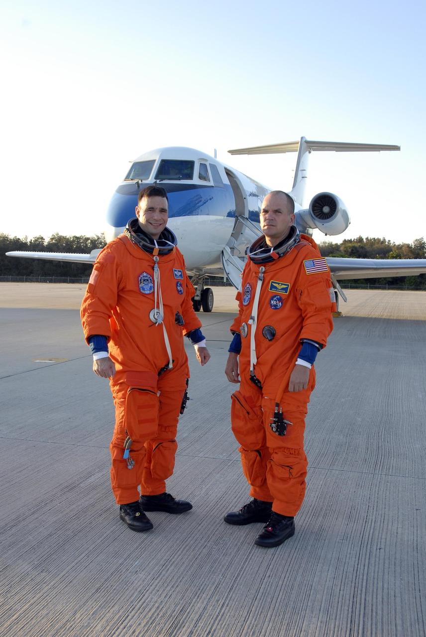 KENNEDY SPACE CENTER, FLA. --  Mission STS-117 Commander Rick Sturckow (left) and Pilot Lee Archambault, dressed in their launch suits, arrive at the Shuttle Landing Facility to begin practice flights on the shuttle training aircraft (STA) during Terminal Countdown Demonstration Test (TCDT) activities. The STA is a Grumman American Aviation-built Gulf Stream II jet that was modified to simulate an orbiter's cockpit, motion and visual cues, and handling qualities. In flight, the STA duplicates the orbiter's atmospheric descent trajectory from approximately 35,000 feet altitude to landing on a runway. Because the orbiter is unpowered during re-entry and landing, its high-speed glide must be perfectly executed the first time. The mission payload aboard Space Shuttle Atlantis is the S3/S4 integrated truss structure, along with a third set of solar arrays and batteries. The crew of six astronauts will install the truss to continue assembly of the International Space Station.  STS-117 is the 118th space shuttle flight and the 21st flight to the station. Photo credit: NASA/Kim Shiflett