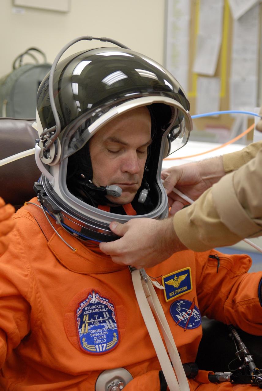 KENNEDY SPACE CENTER, FLA. -- Mission STS-117 Commander Rick Sturckow checks the fit of his launch suit and helmet, part of pre-launch preparations during terminal countdown demonstration test (TCDT) activities. The mission crew is at KSC for the TCDT, which includes a simulated launch countdown. The STS-117 mission is No. 21 to the International Space Station. Mission payloads aboard Atlantis include the S3/S4 integrated truss structure, a third set of solar arrays and batteries. The crew of six astronauts will install the truss to continue assembly of the station. Launch is scheduled for no earlier than March 15. Photo credit: NASA/Kim Shiflett.