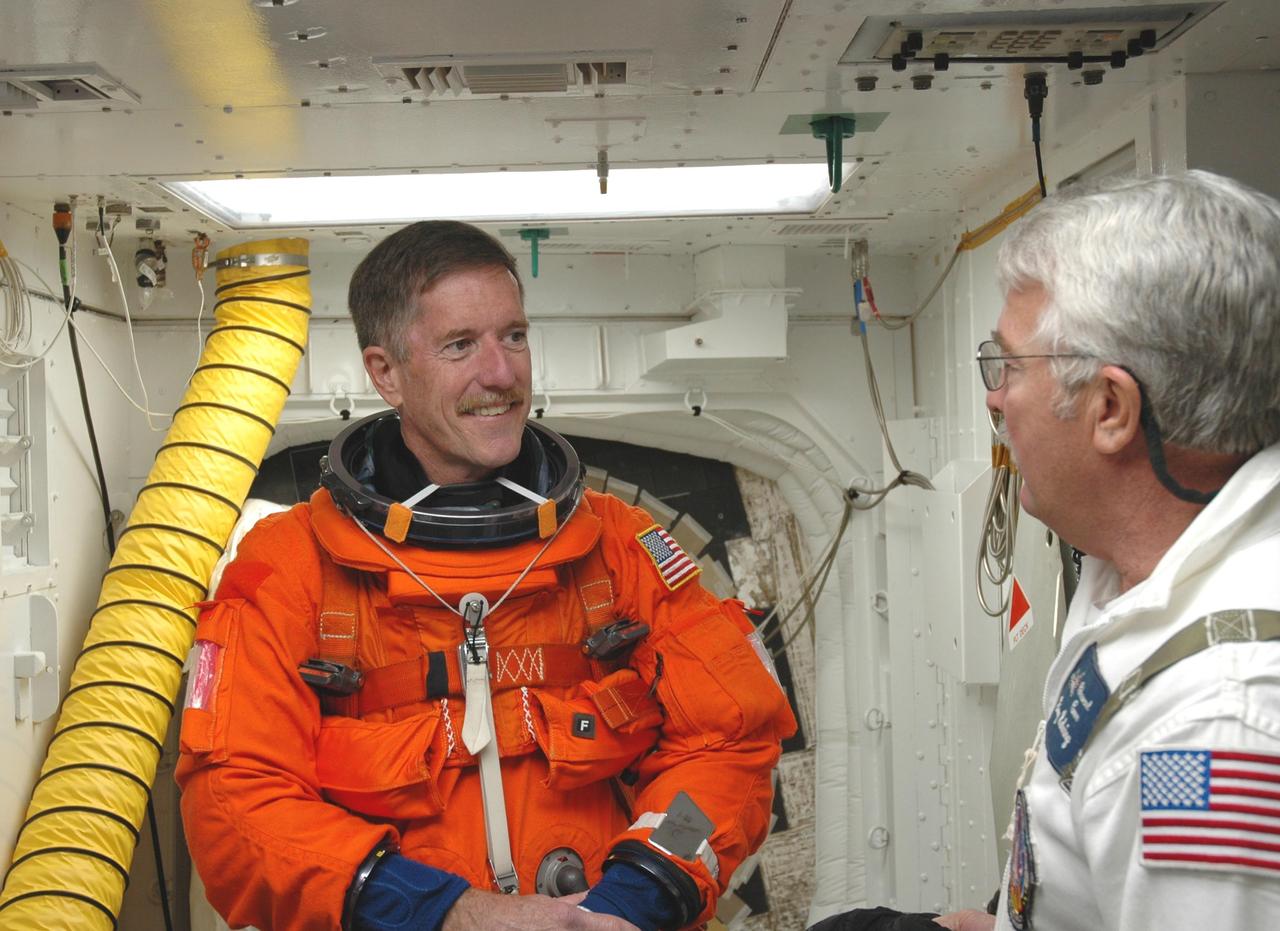 KENNEDY SPACE CENTER, FLA. -- In the white room on Launch Pad 39A, Mission STS-117 Mission Specialist James Reilly is helped with his gear before entering Space Shuttle Atlantis. The STS-117 crew practices for launch with a simulation of activities, from suit-up to countdown in the orbiter during terminal countdown demonstration test activities. The STS-117 mission is No. 21 to the International Space Station. Mission payloads aboard Atlantis include the S3/S4 integrated truss structure, a third set of solar arrays and batteries. The crew of six astronauts will install the truss to continue assembly of the station. Launch is scheduled for no earlier than March 15. Photo credit: NASA/Jim Grossmann