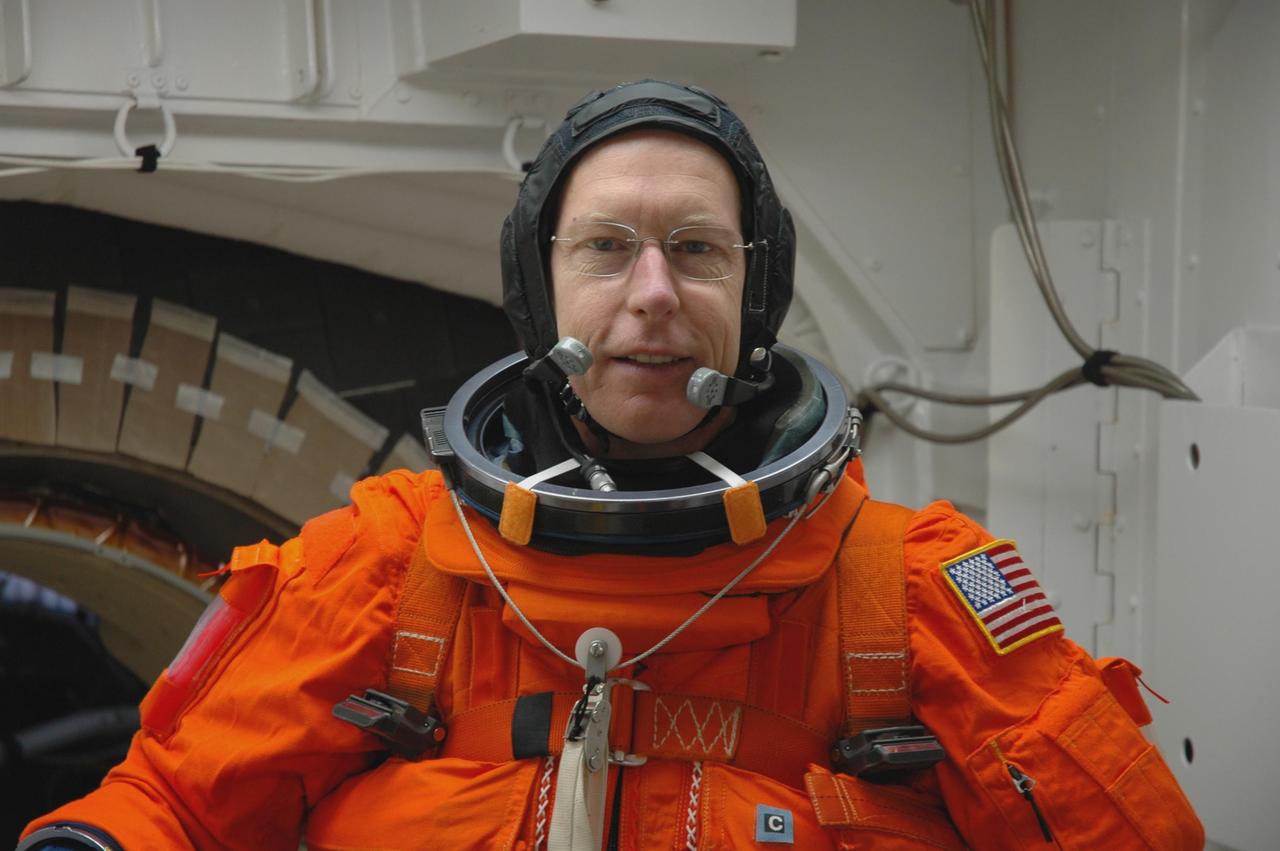 KENNEDY SPACE CENTER, FLA. -- In the white room on Launch Pad 39A, Mission STS-117 Mission Specialist Patrick Forrester prepares to enter Space Shuttle Atlantis. The STS-117 crew practices for launch with a simulation of activities, from suit-up to countdown in the orbiter during terminal countdown demonstration test activities. The STS-117 mission is No. 21 to the International Space Station. Mission payloads aboard Atlantis include the S3/S4 integrated truss structure, a third set of solar arrays and batteries. The crew of six astronauts will install the truss to continue assembly of the station. Launch is scheduled for no earlier than March 15. Photo credit: NASA/Jim Grossmann