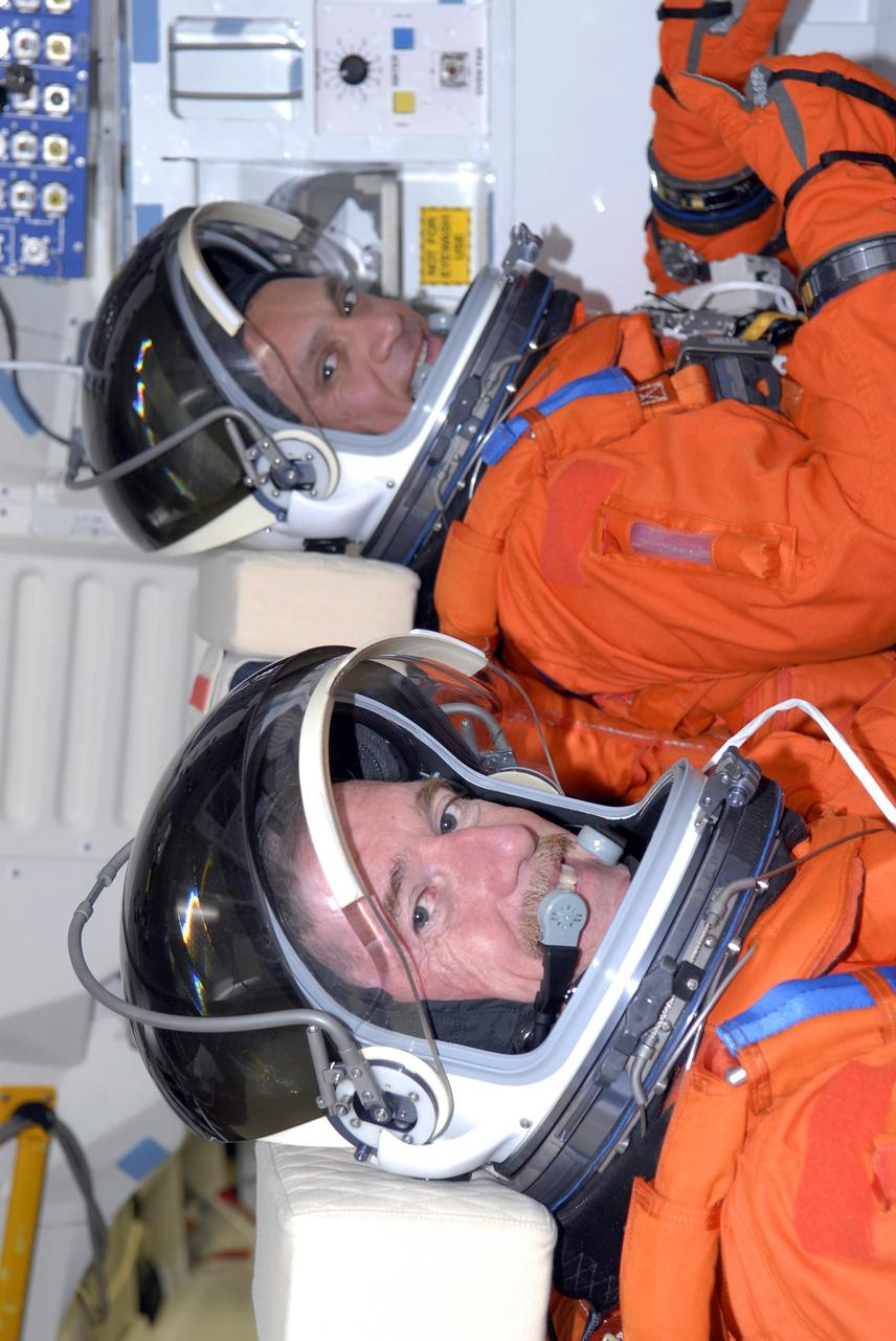KENNEDY SPACE CENTER, FLA. -- Mission STS-117 Mission Specialists James Reilly (left) and Danny Olivas sit in the mid-deck of Space Shuttle Atlantis at Launch Pad 39A to participate in a simulated launch countdown that is part of the prelaunch preparations known as terminal countdown demonstration test (TCDT). The TCDT also includes M-113 armored personnel carrier training and payload familiarization. The STS-117 mission is No. 21 to the International Space Station. Mission payloads aboard Atlantis include the S3/S4 integrated truss structure, a third set of solar arrays and batteries. The crew of six astronauts will install the truss to continue assembly of the station. Launch is scheduled for no earlier than March 15. Photo credit: NASA/Kim Shiflett.